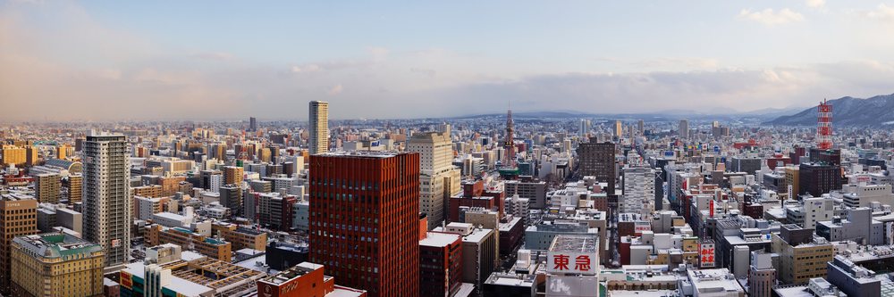 City skyline of sapporo, japan with snow and mountains