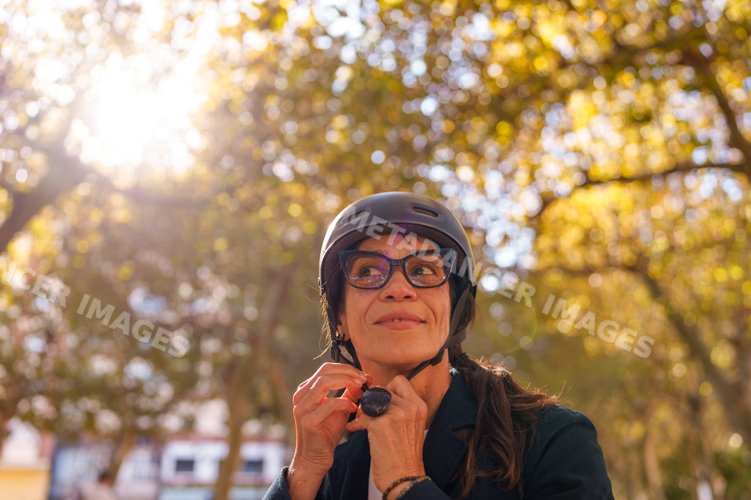 Hispanic woman adjusting helmet outdoors