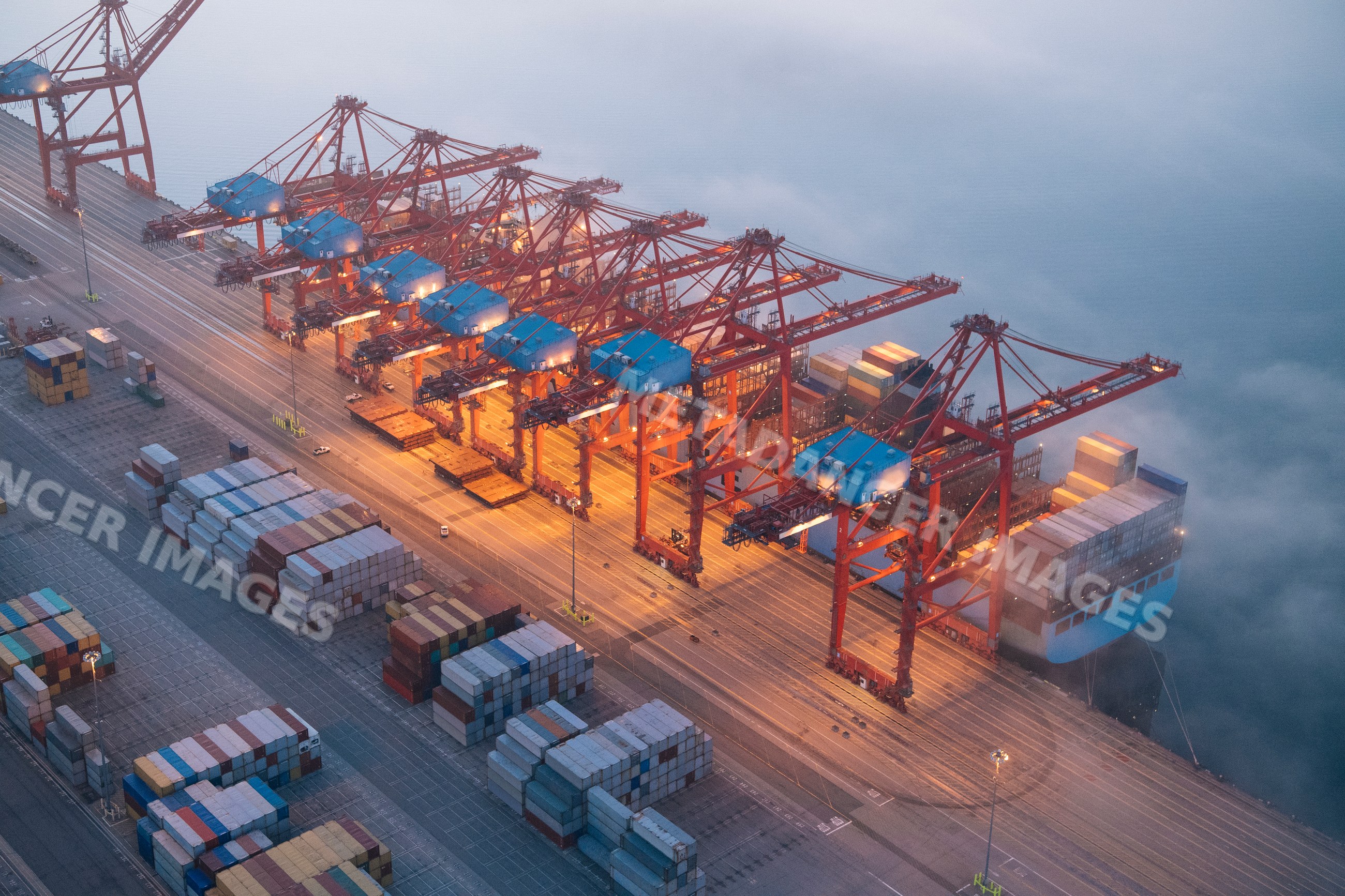Cranes loading containers onto a cargo ship at a port in Long Beach