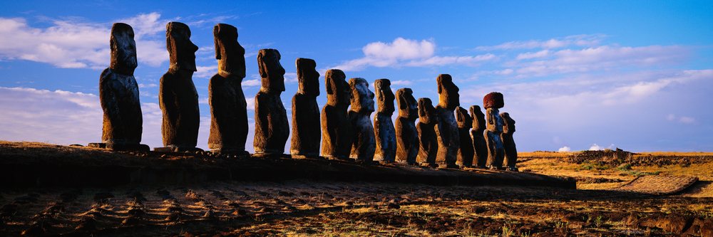 Moai statues on easter island at sunset with dramatic sky
