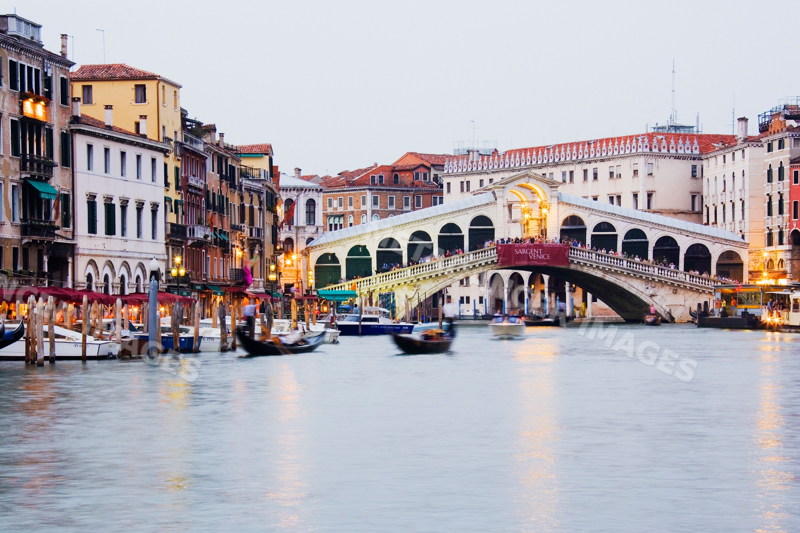 Rialto bridge over grand canal with gondolas in venice, italy