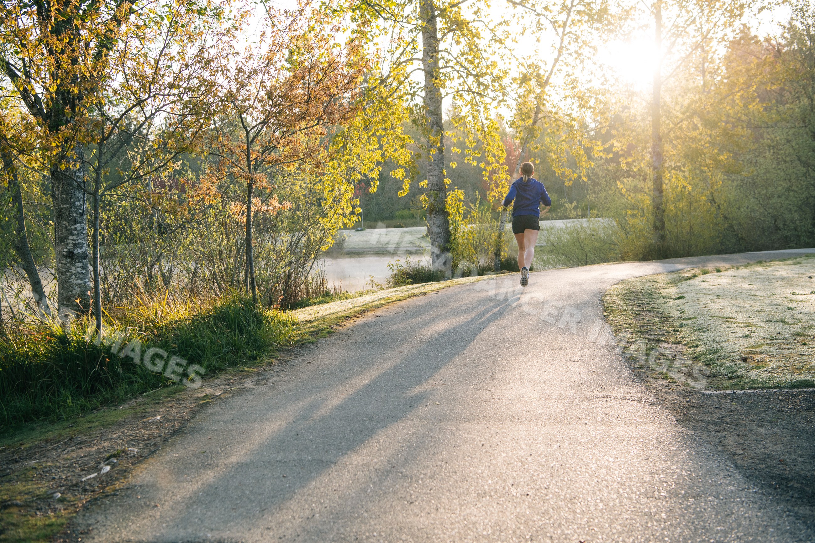 White runner jogging on park path