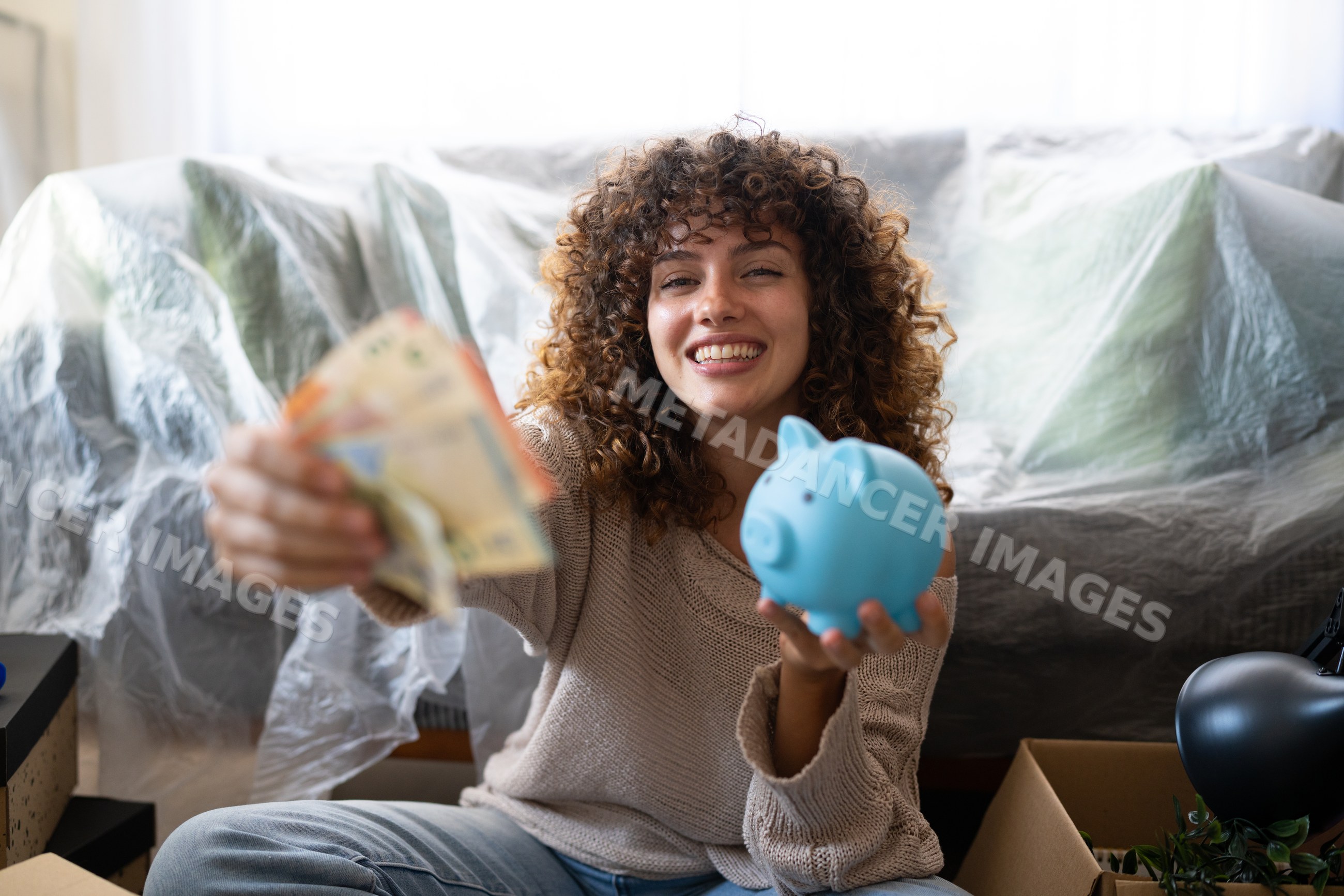 White woman holding money and blue piggy bank