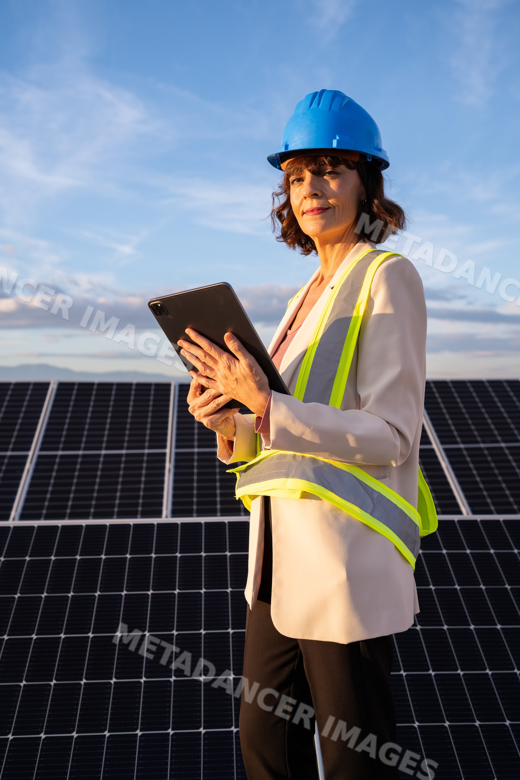 White woman engineer with tablet at solar panel installation