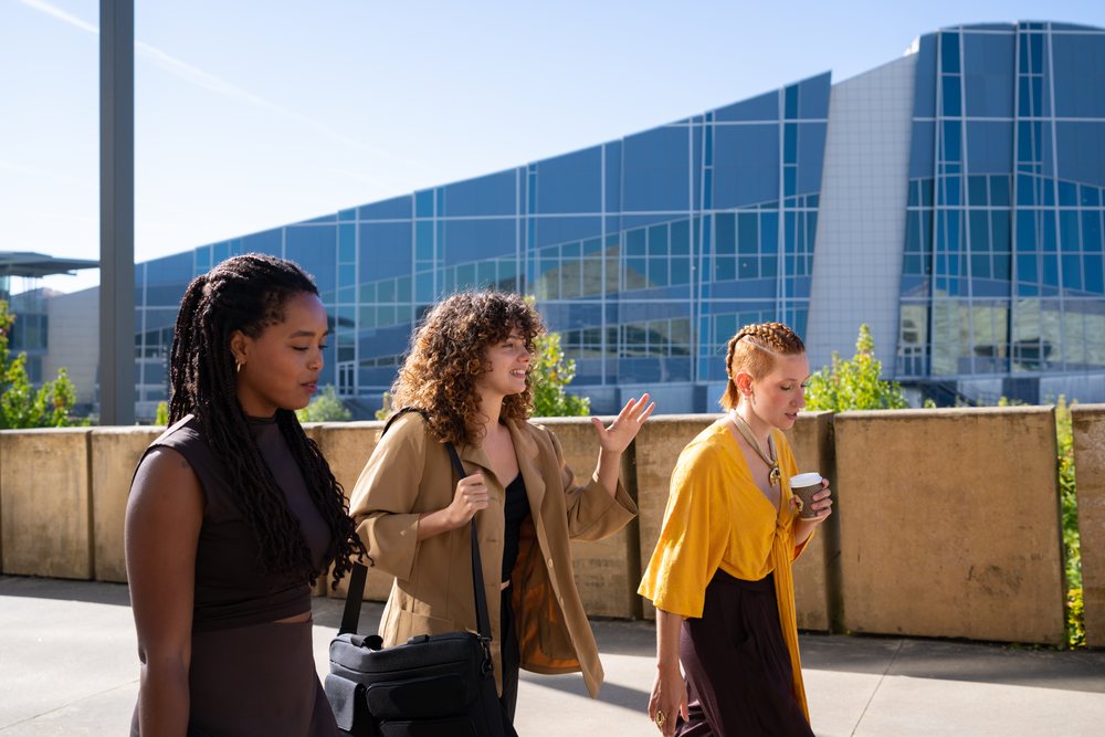 Three African American and white women walking and talking