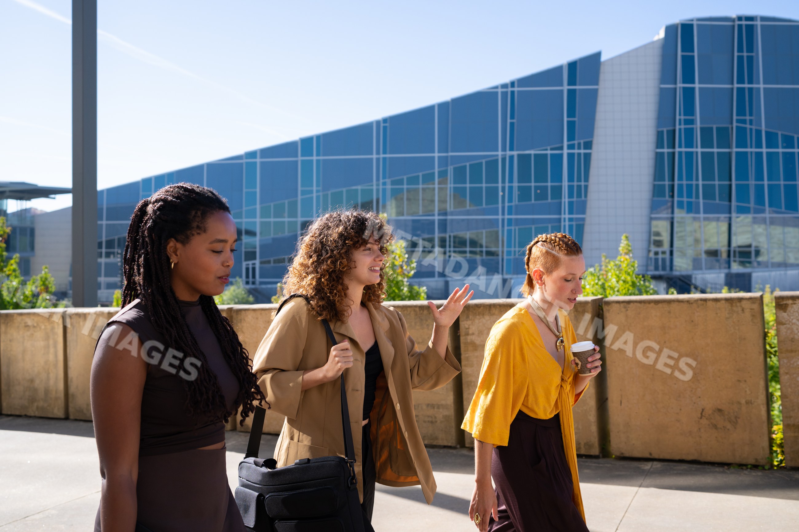 Three African American and white women walking and talking
