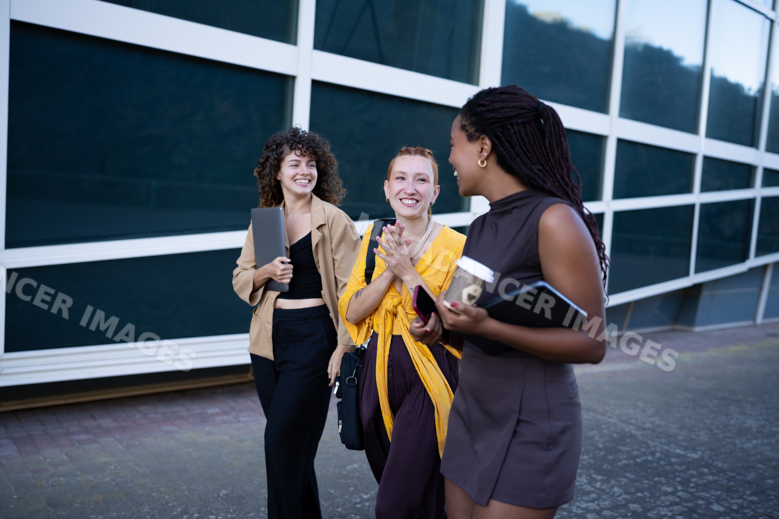 Three African American and white women walking and chatting together