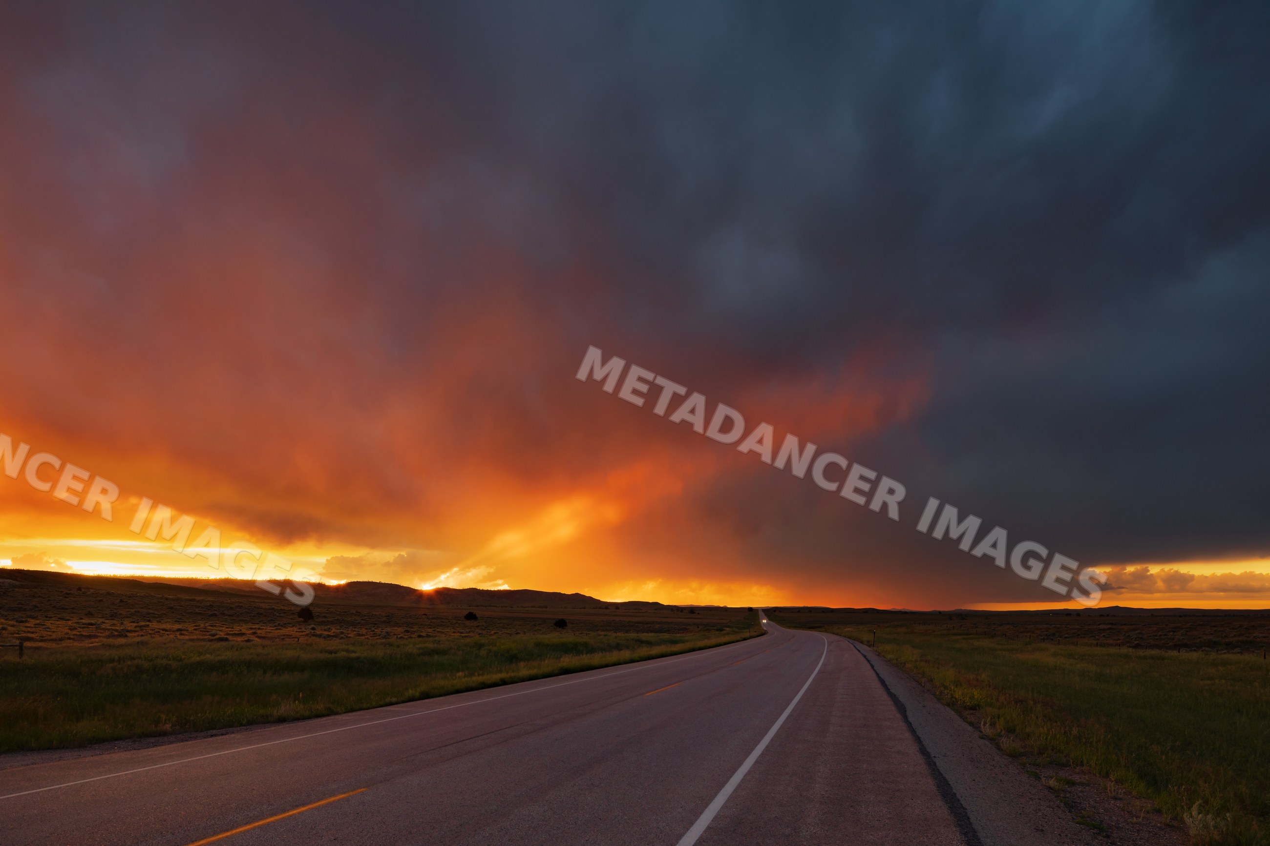 Sunset over highway 59 north of gillette, wyoming with storm clouds