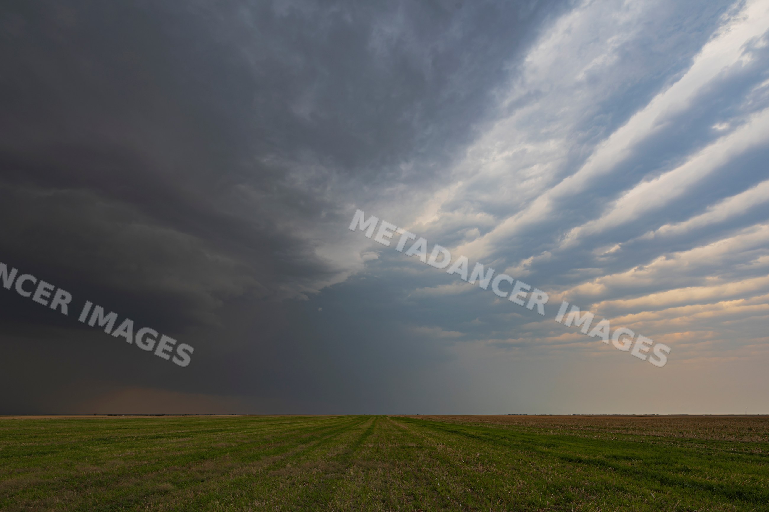 Supercell storm with herringbone clouds over green field in Tornado