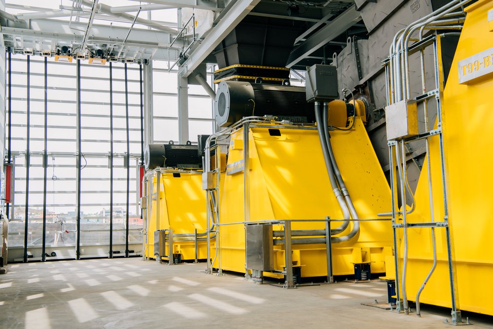 Large yellow industrial machinery seen inside an indoor factory space