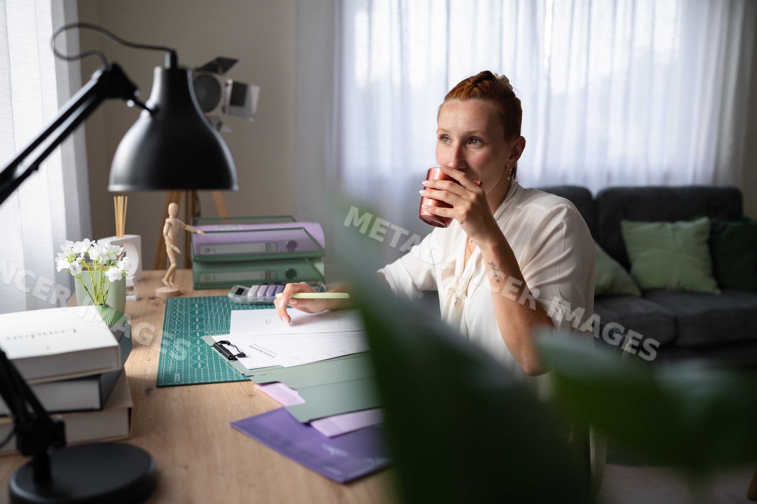 White Woman working remotely drinks coffee in a home office in Galicia