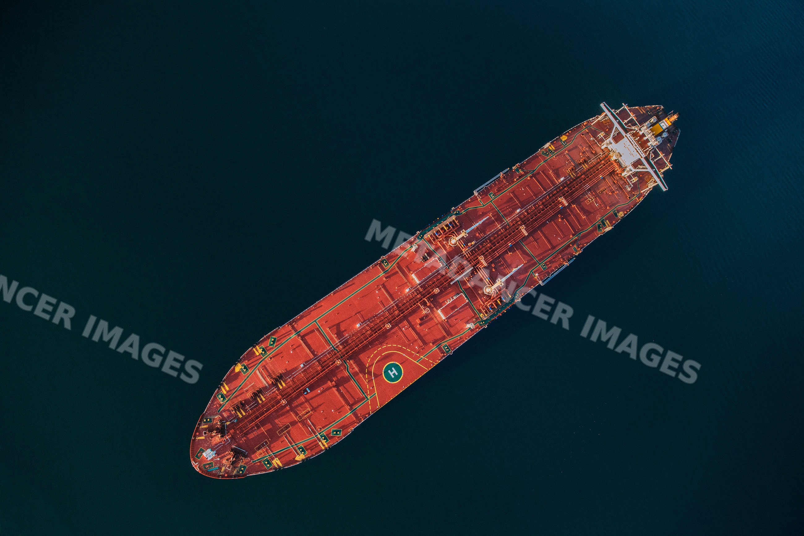 Oil tanker with helipad from aerial view in a beach