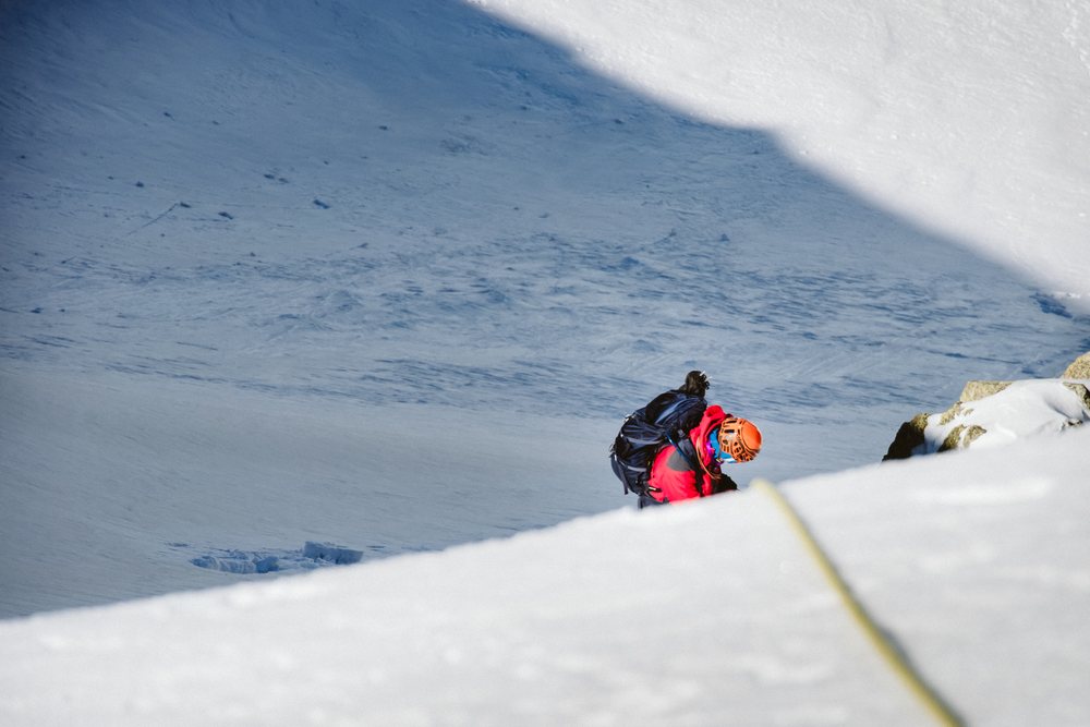 Mountaineer climbing snowy mountain slope