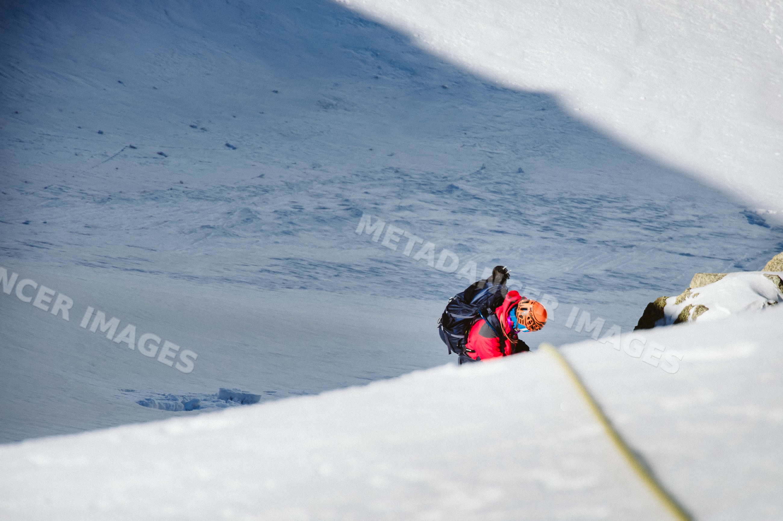 Mountaineer climbing snowy mountain slope