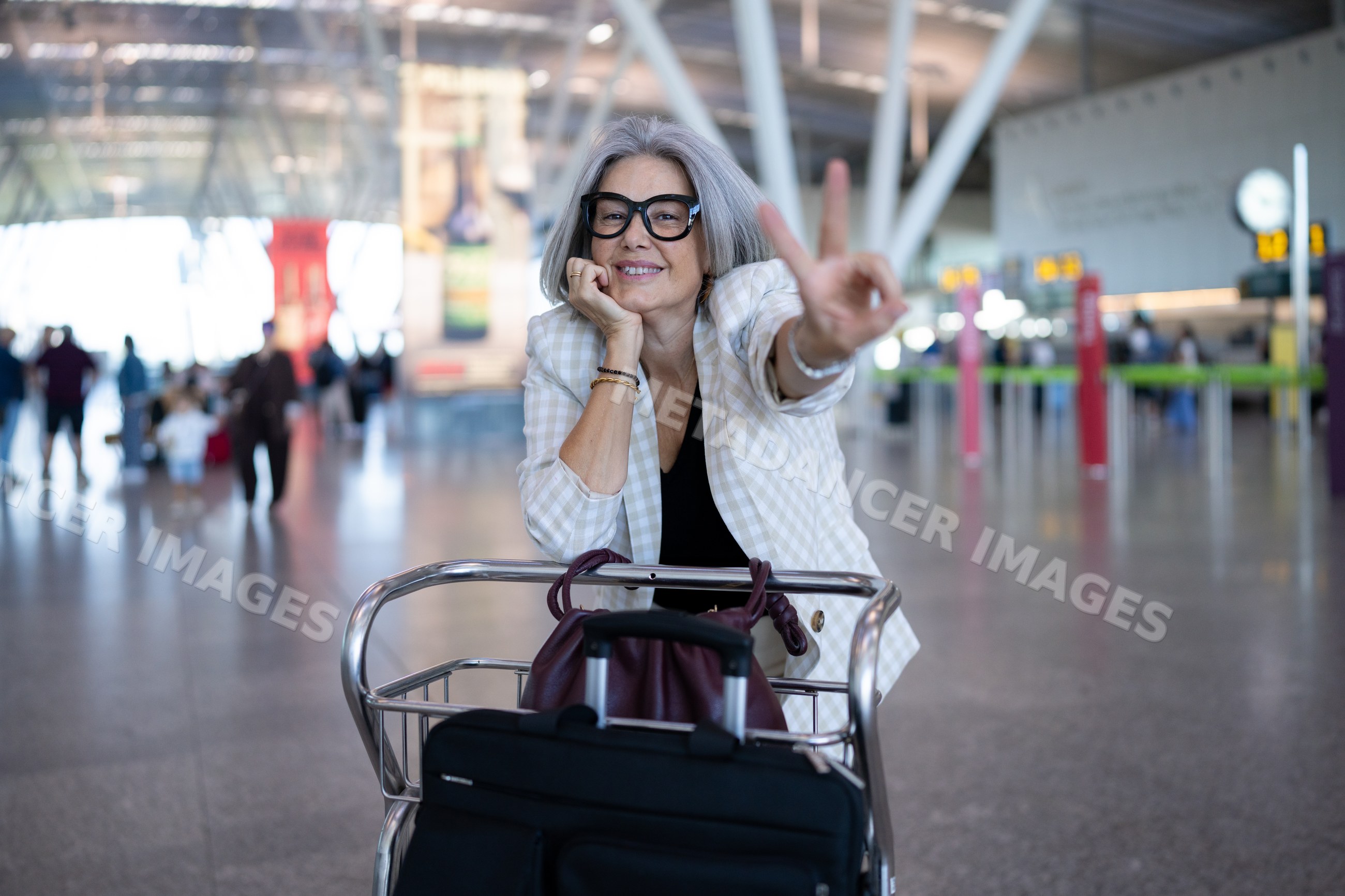 White woman posing with luggage trolley