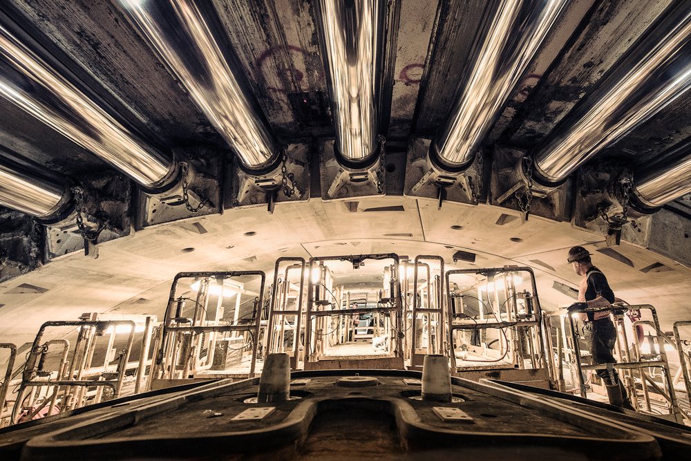 Worker inspects tunnel boring machine during drilling