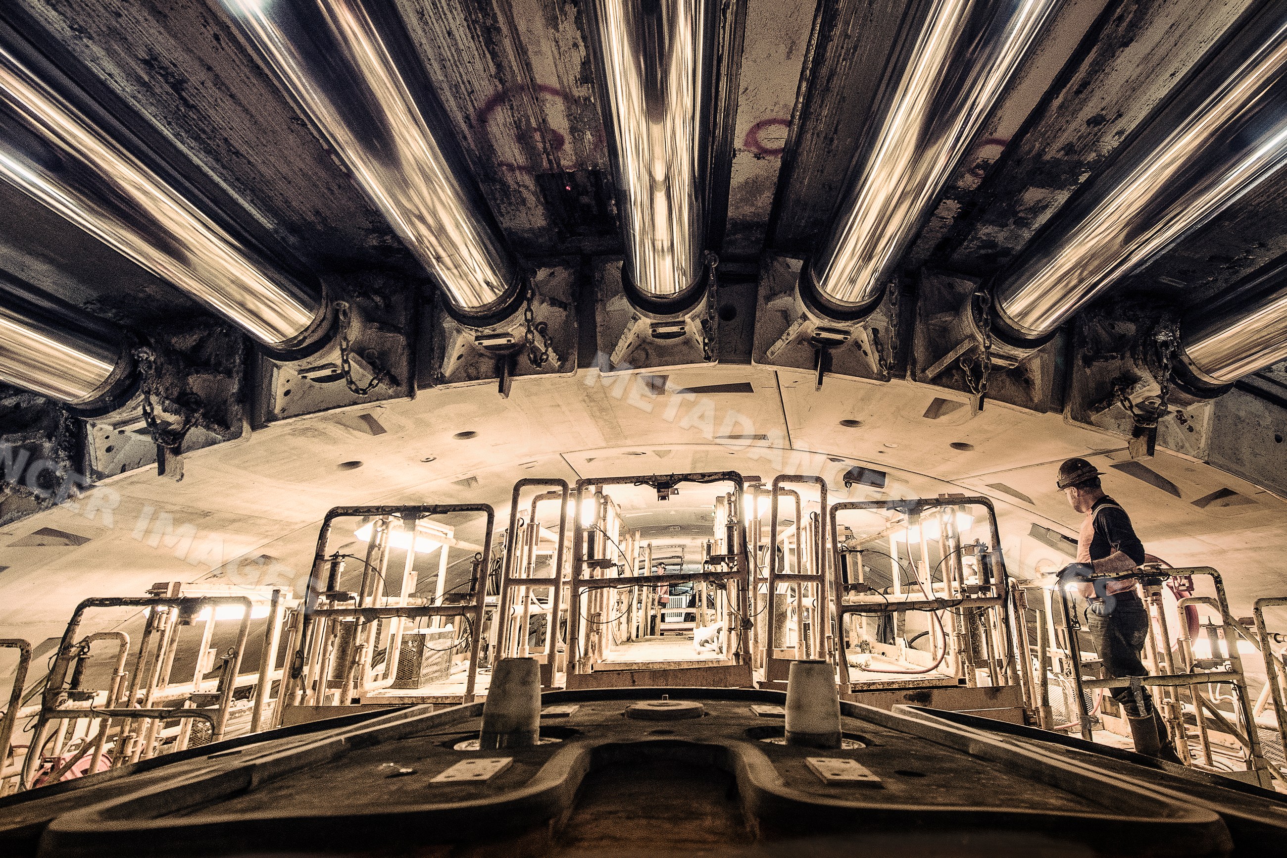 Worker inspects tunnel boring machine during drilling