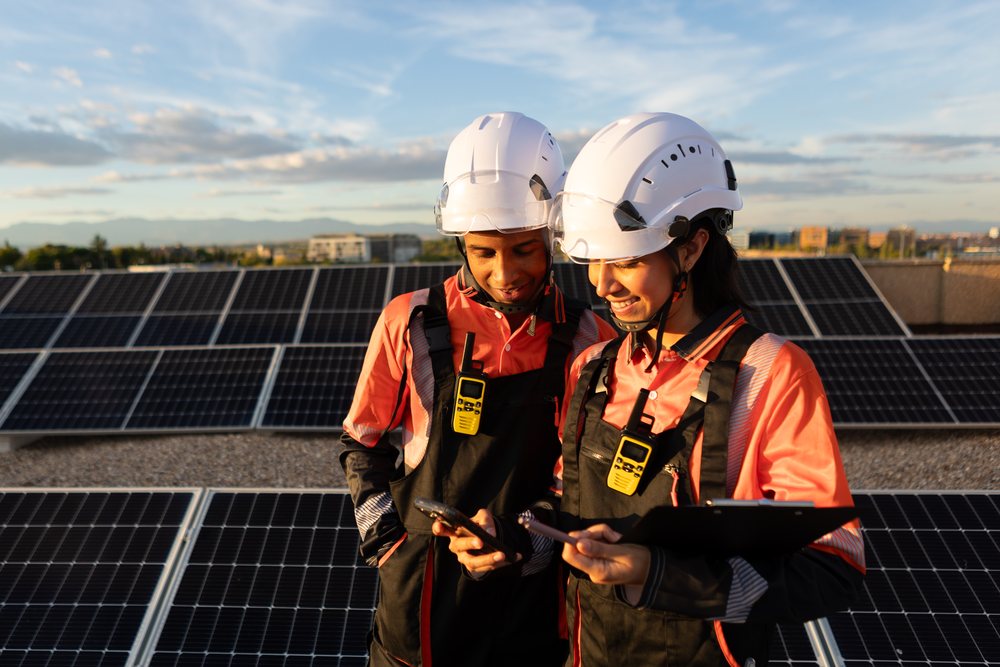 Hispanic workers inspecting solar panels outdoors at sunset in Madrid