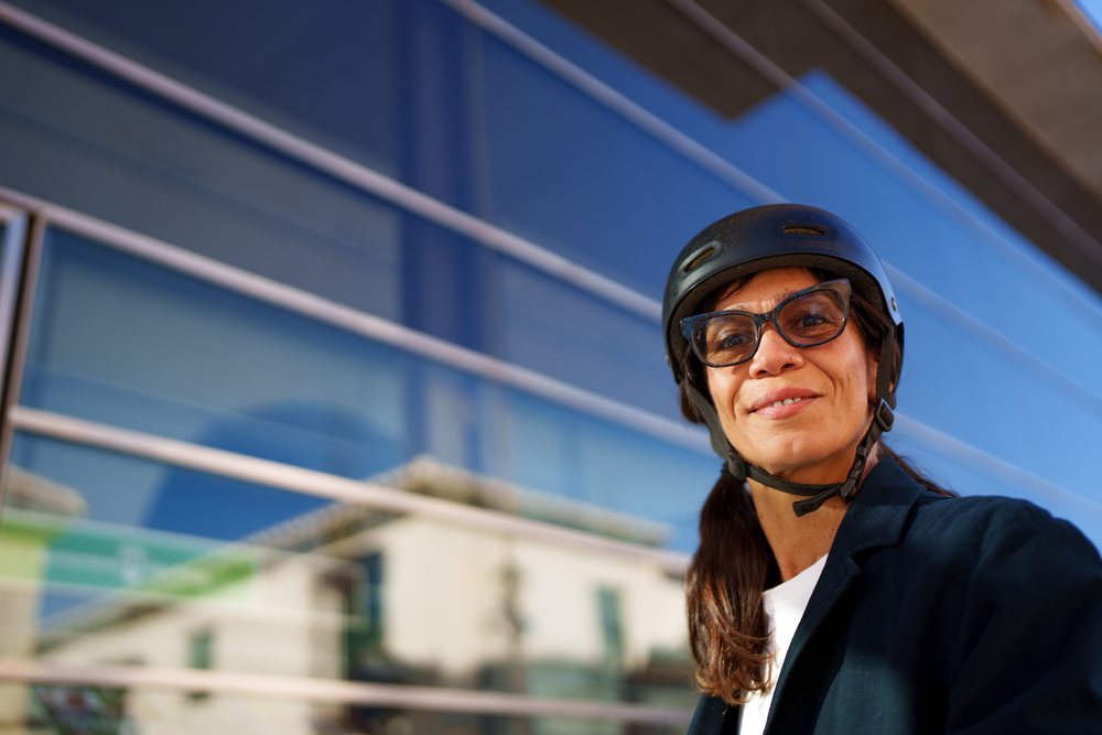 Hispanic woman wearing helmet and glasses outdoors