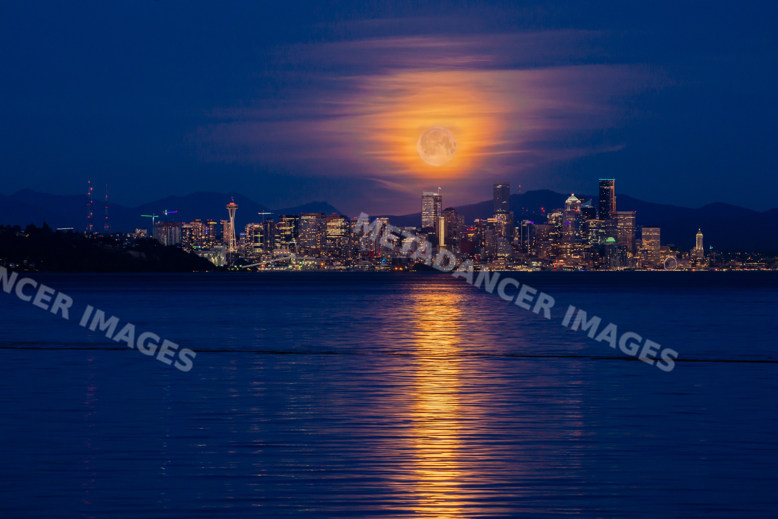Seattle skyline at night with full moon reflecting on water
