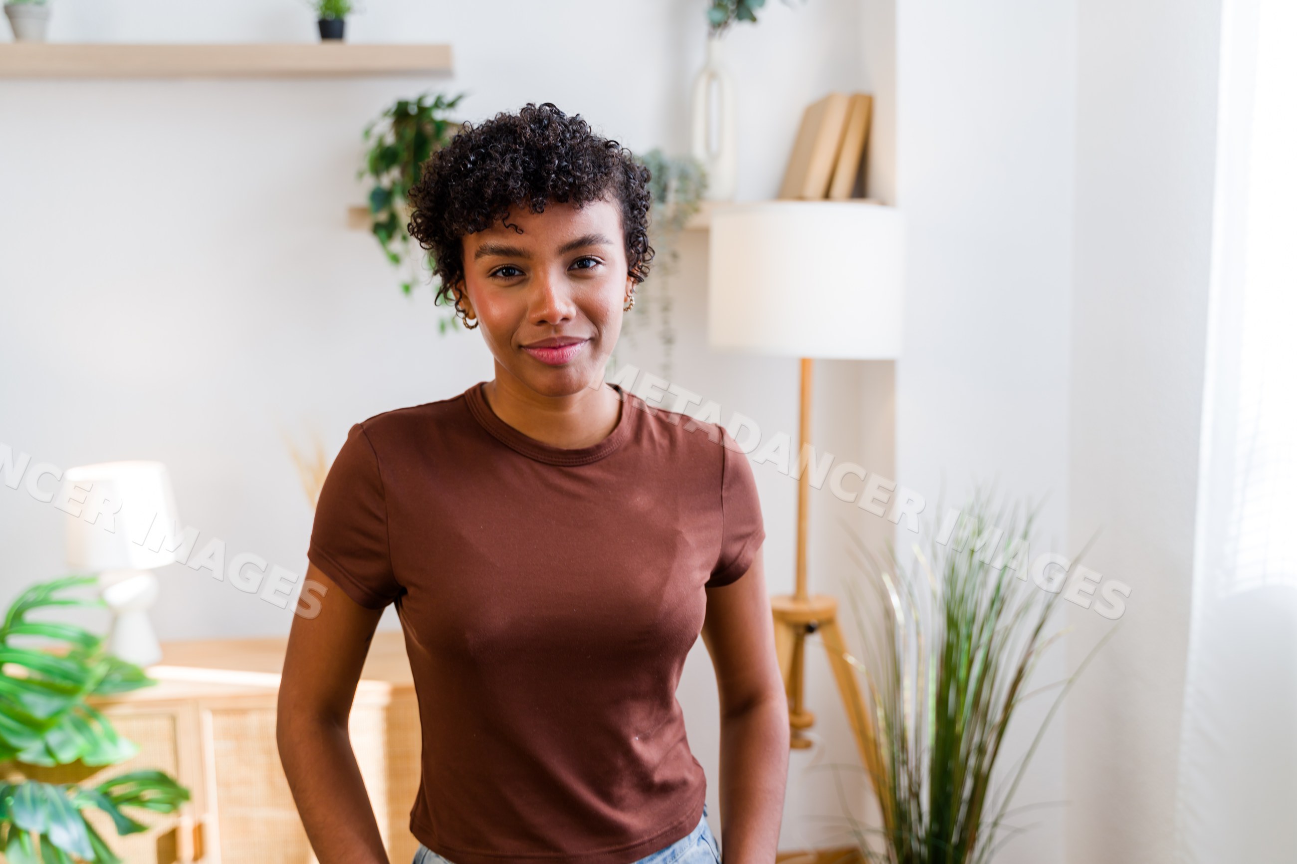 African American woman with curly hair standing indoors in modern room