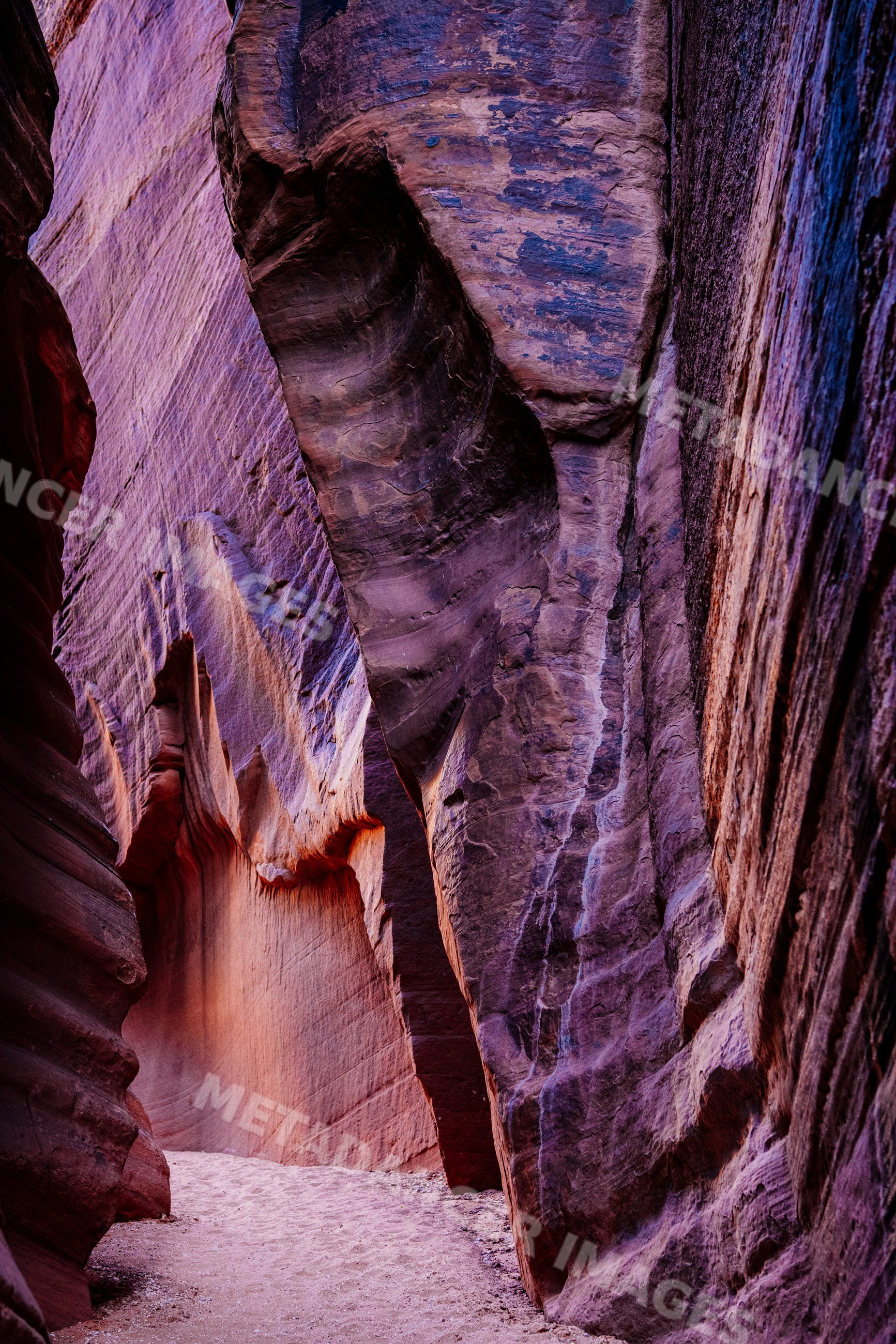 Buckskin gulch slot canyon with narrow sandy trail and towering