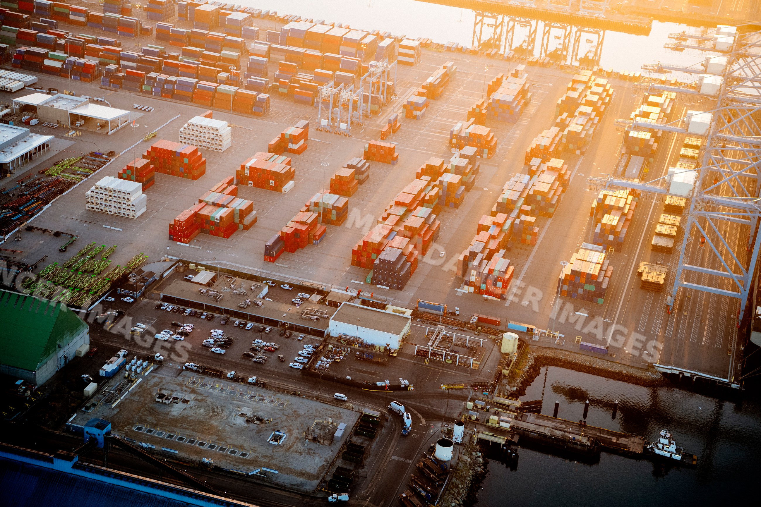Cargo containers stacked at a major container yard during sunset