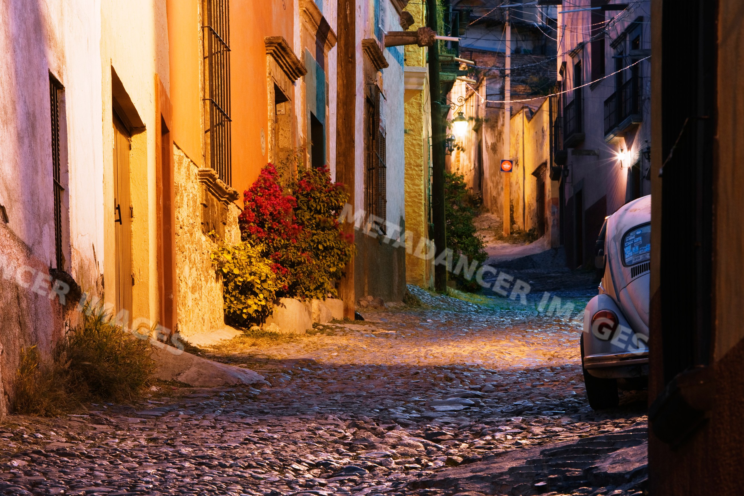 Cobblestone alley with vintage car at dusk mexico