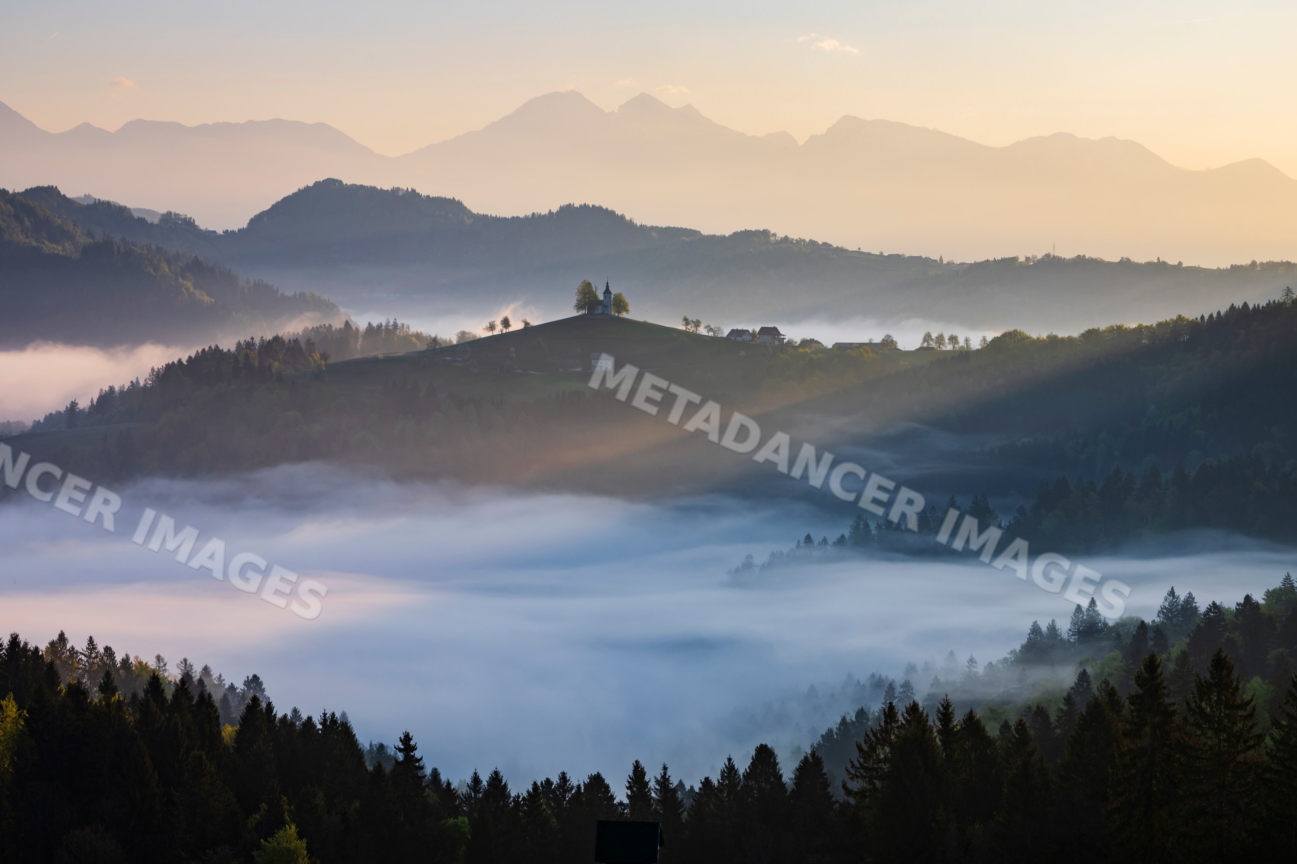 St Thomas's Church on a misty hill at Sunrise in skofja loka