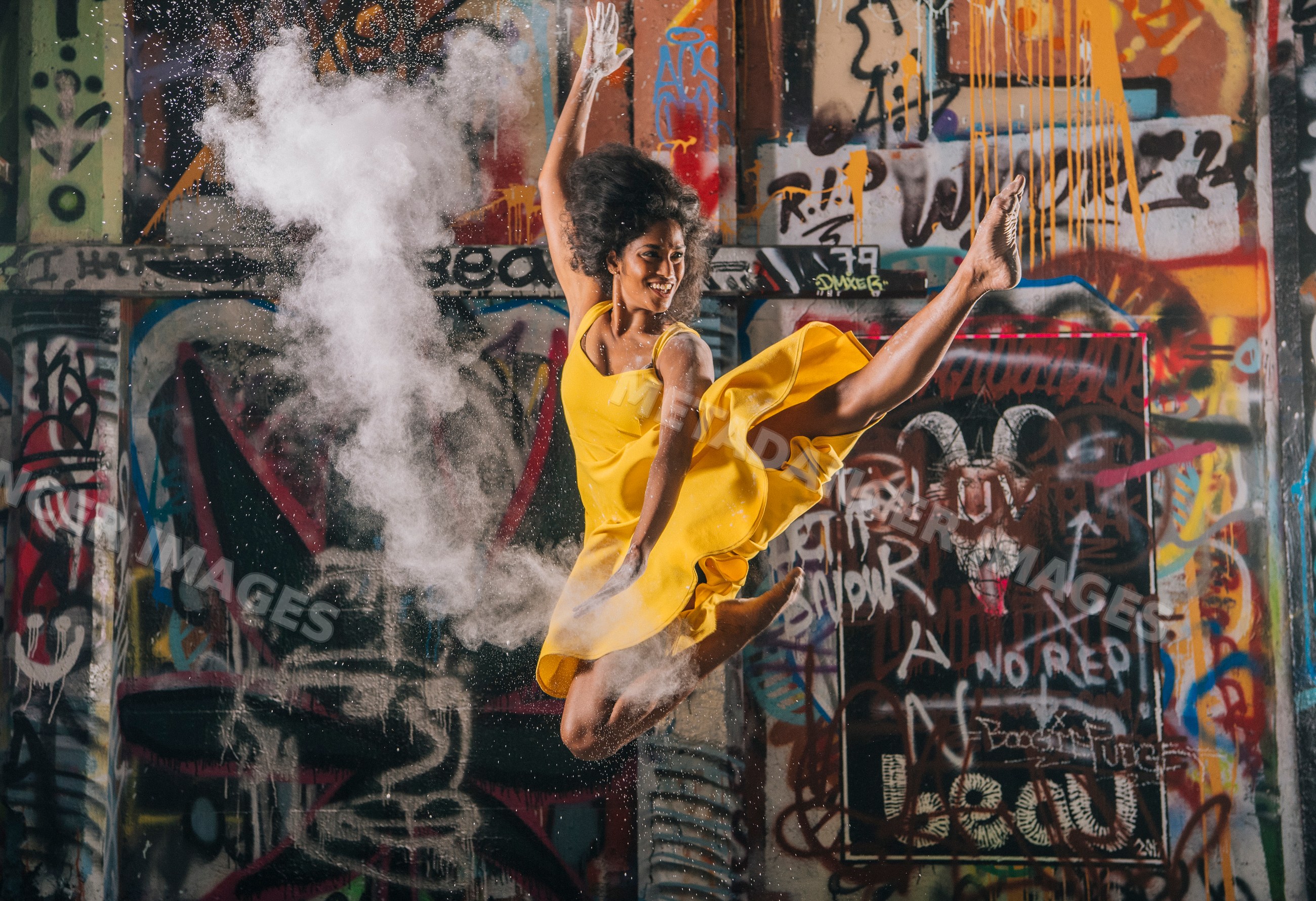 South Asian woman jumping and throwing powder