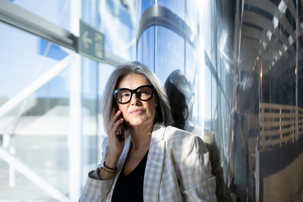 Businesswoman with gray hair making phone call