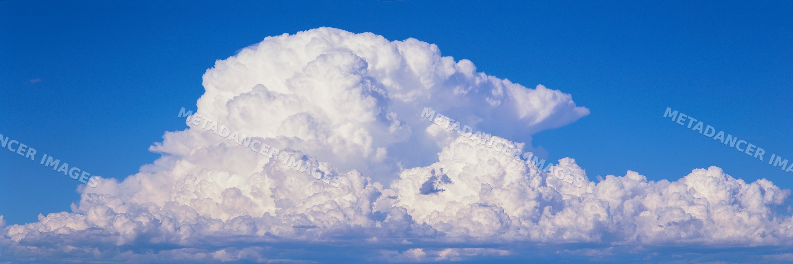 Fluffy cumulus clouds under clear blue sky