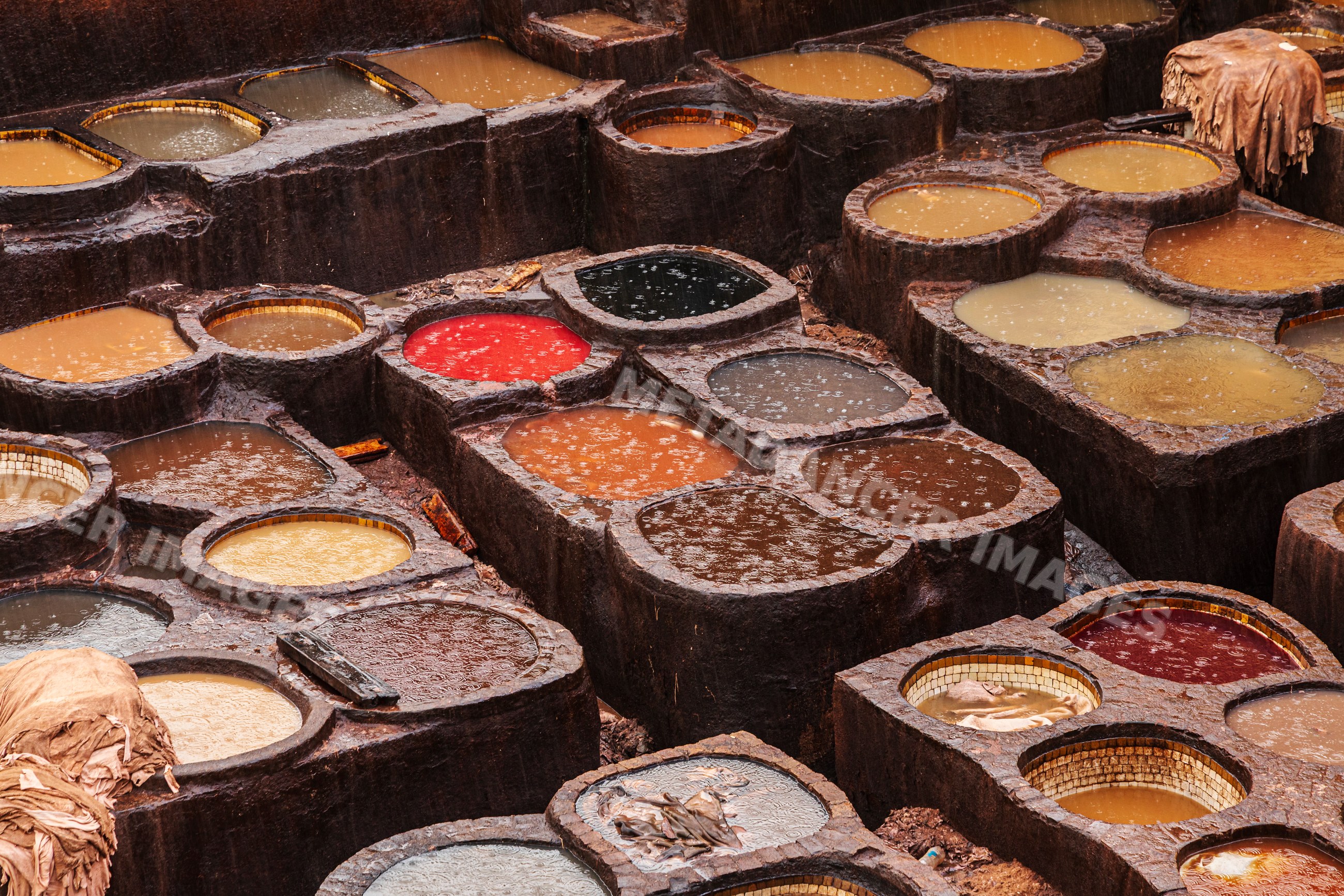 Chouara tannery vats in rain in fes Morocco