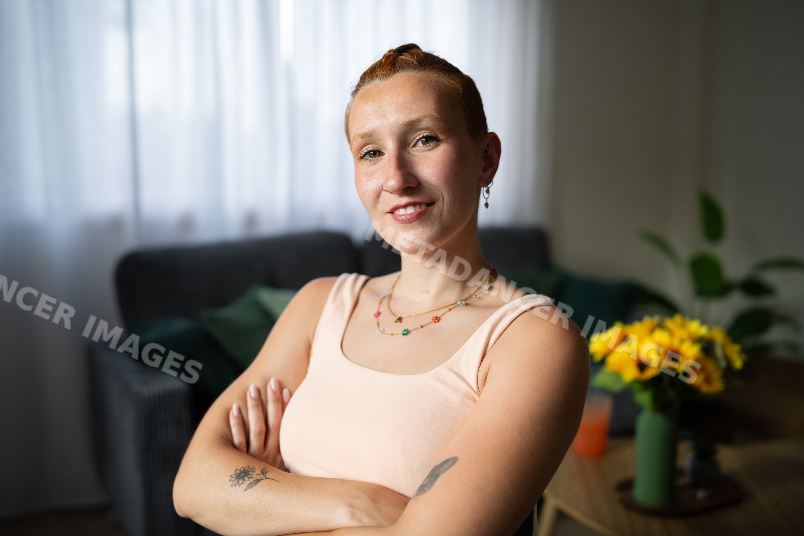 A confident white woman with crossed arms at home in Galicia, Spain