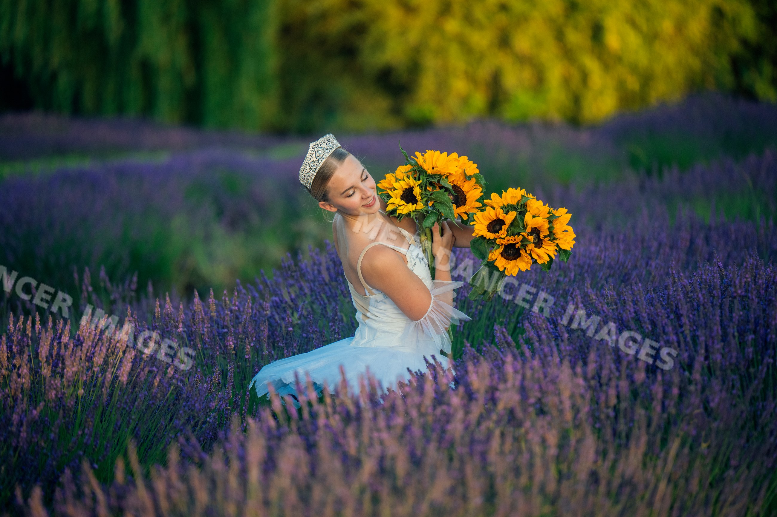 Young white woman wearing crown holds sunflower bouquets