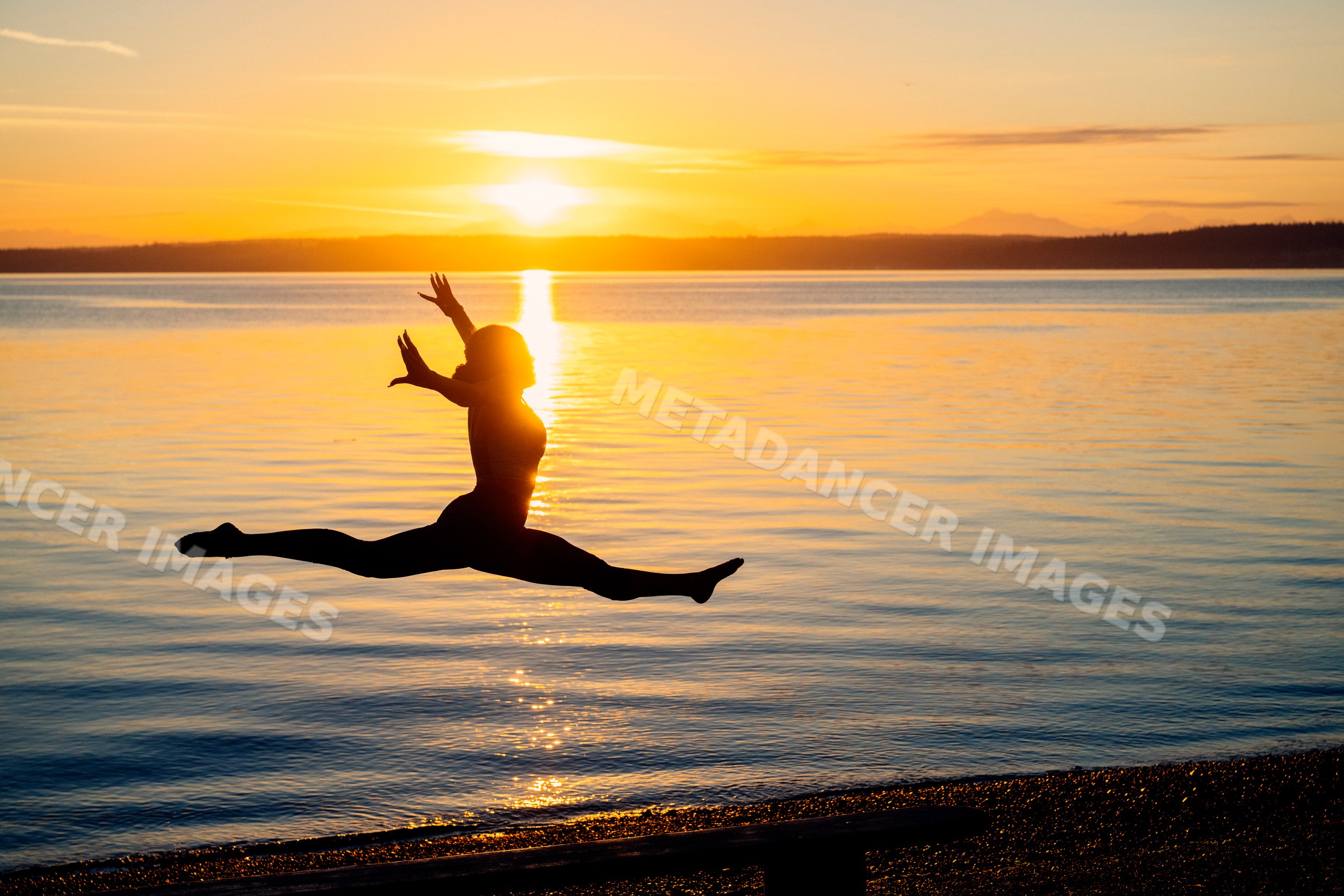 Silhouette of Hispanic woman performing split leap yoga pose