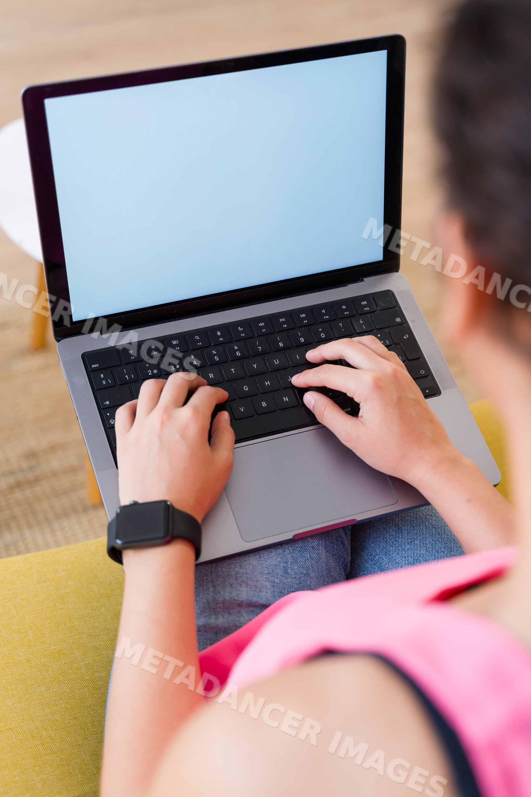 Hispanic Person typing on a laptop indoors