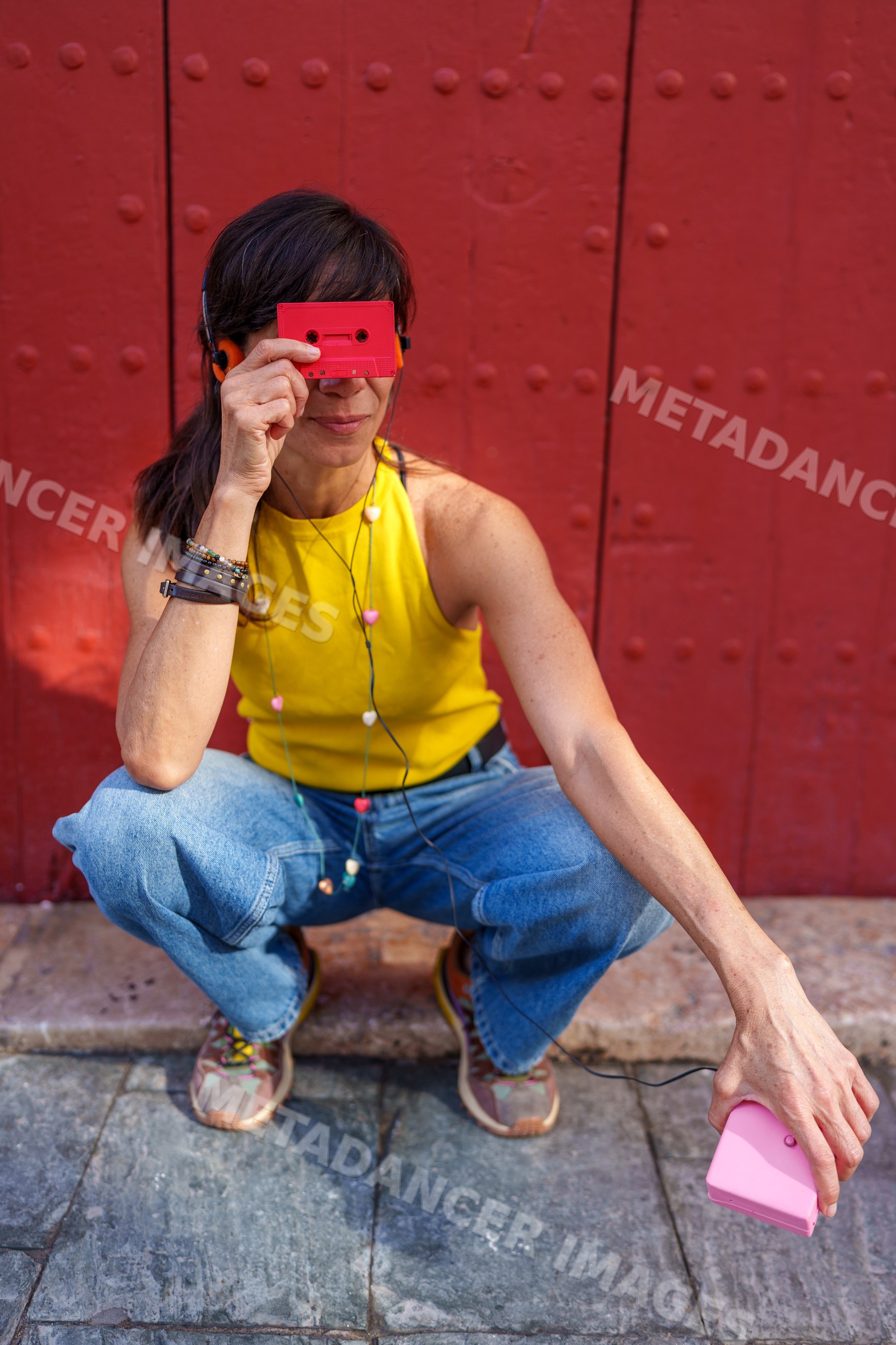 Hispanic woman listening to music with cassette player outdoors