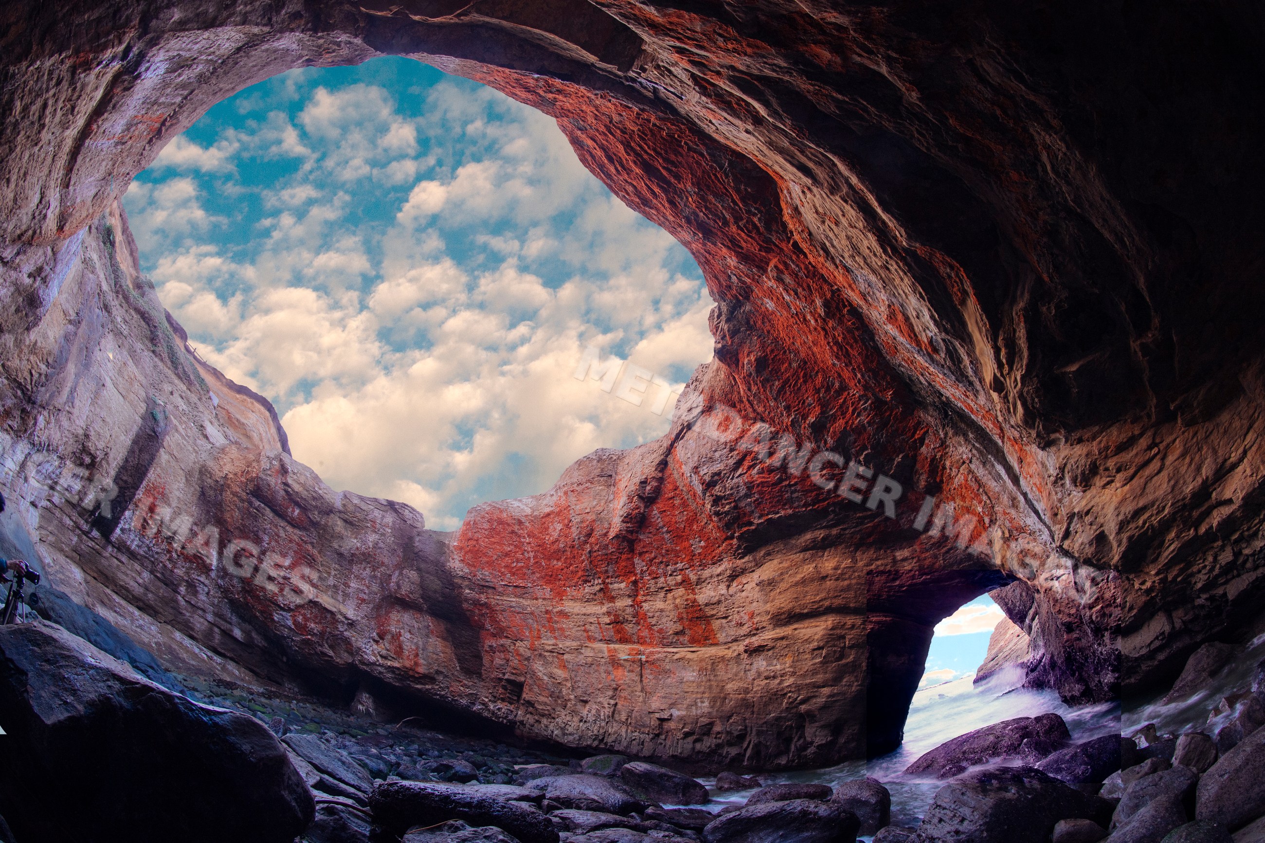 Devils punch bowl cave with rocky shoreline and ocean water