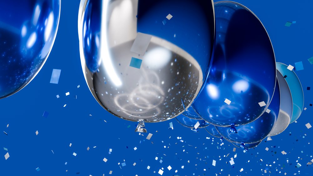 Blue and silver balloons with confetti in festive celebration