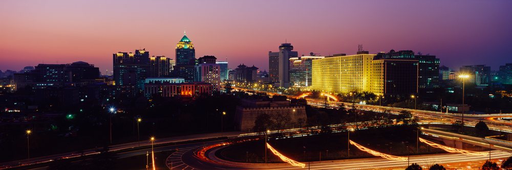 City skyline with traffic and illuminated buildings at sunset