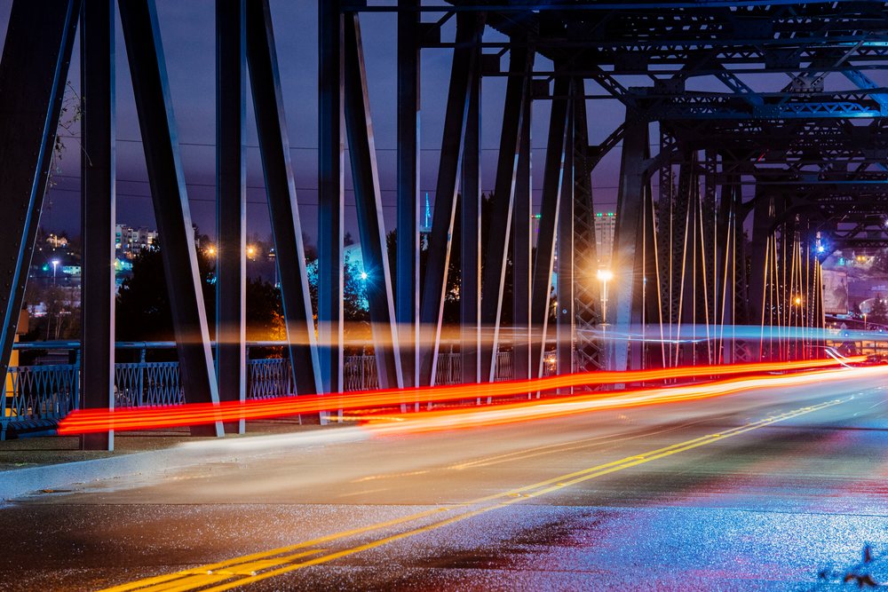 Light trails across steel bridge at night in Tacoma, washington