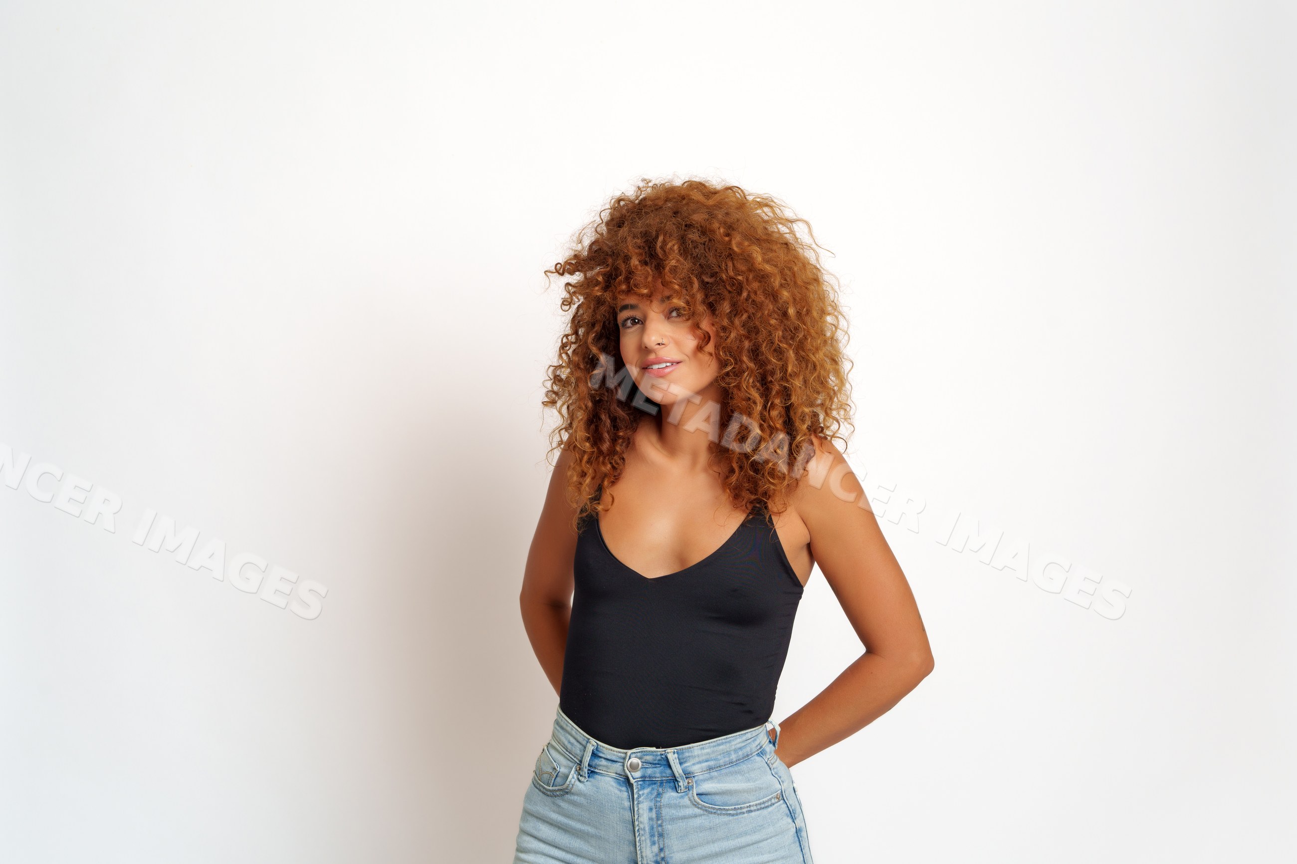 Hispanic woman with curly red hair posing