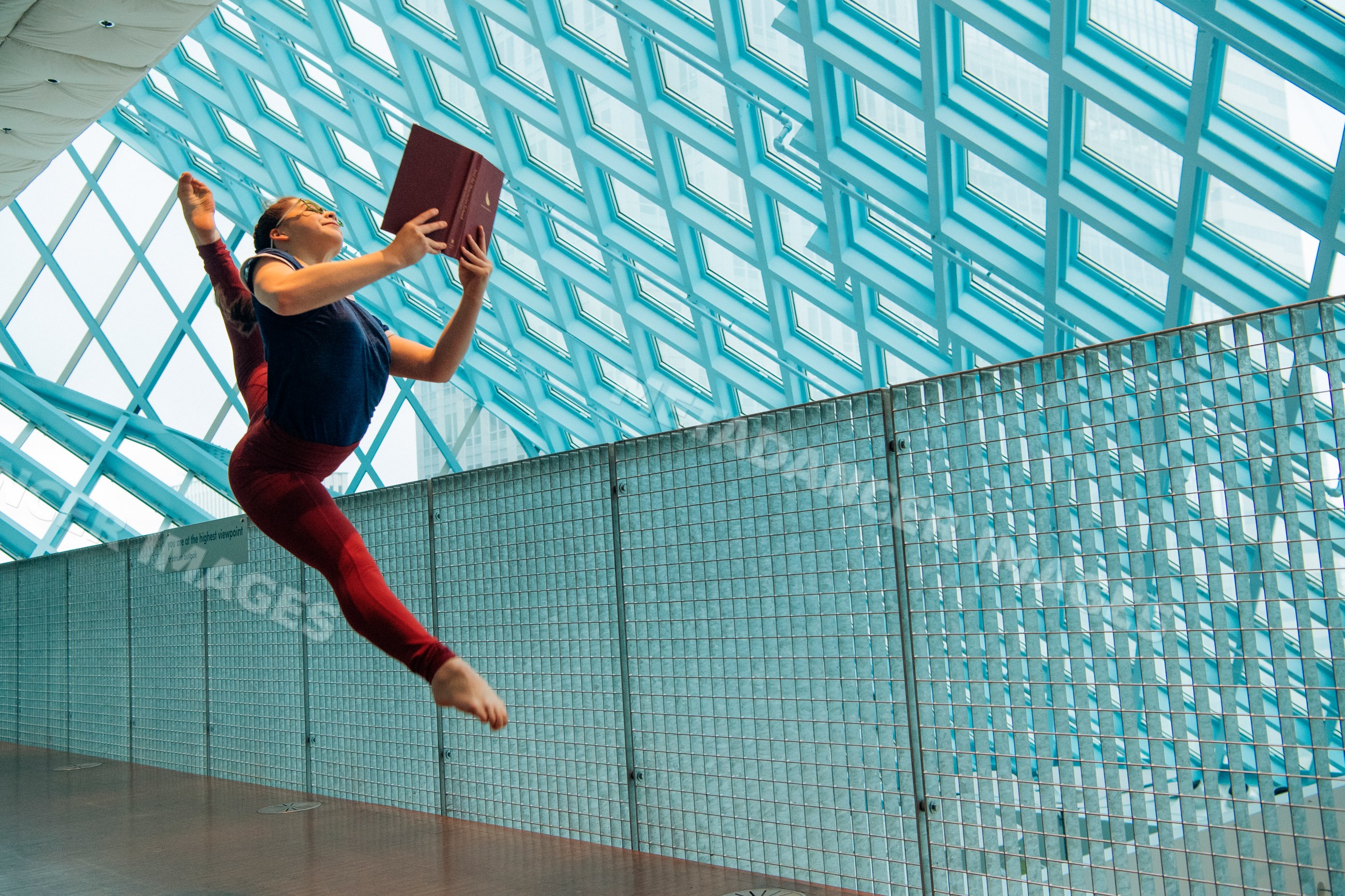 A dancer leaps holding a book