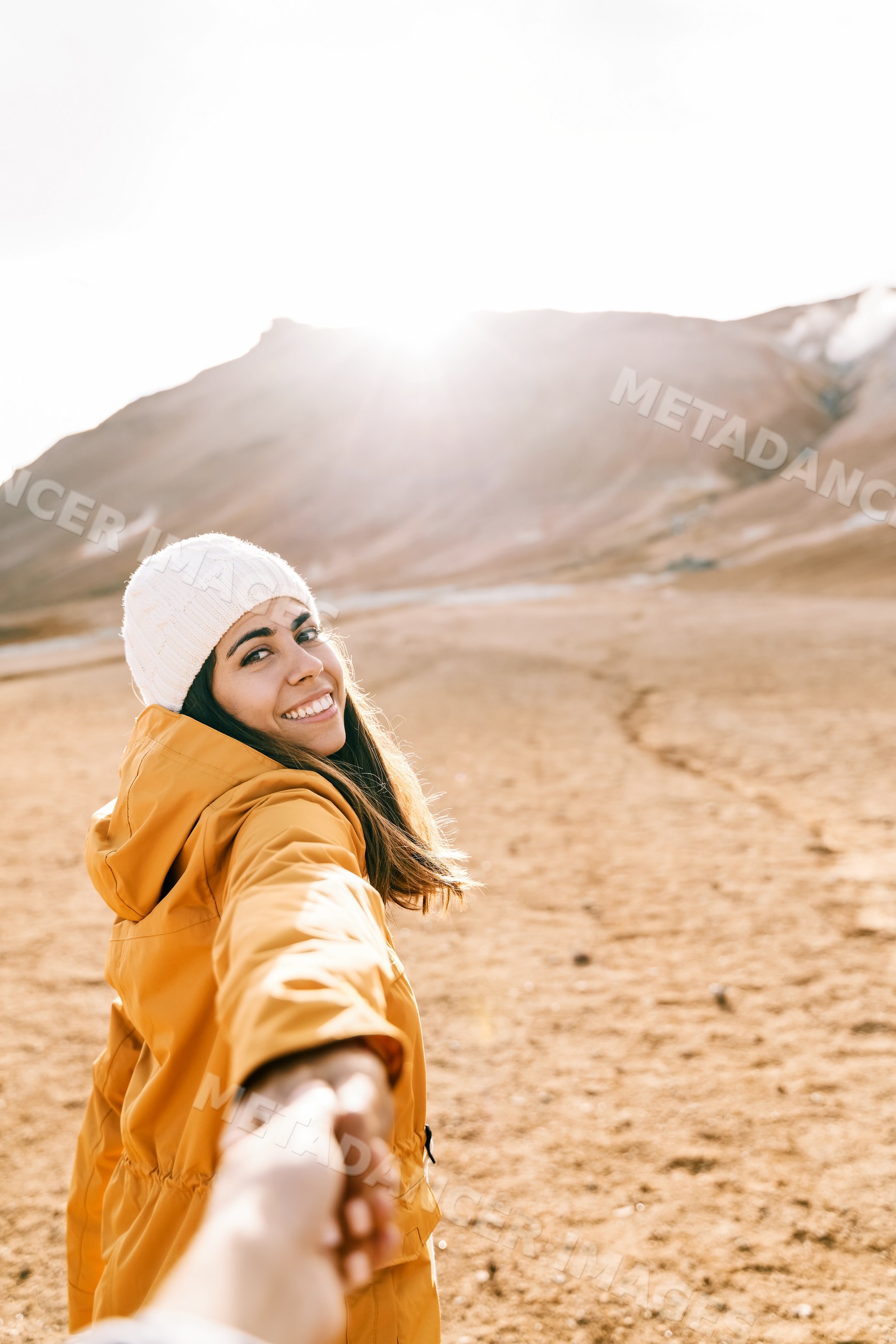 A smiling white woman holds hand