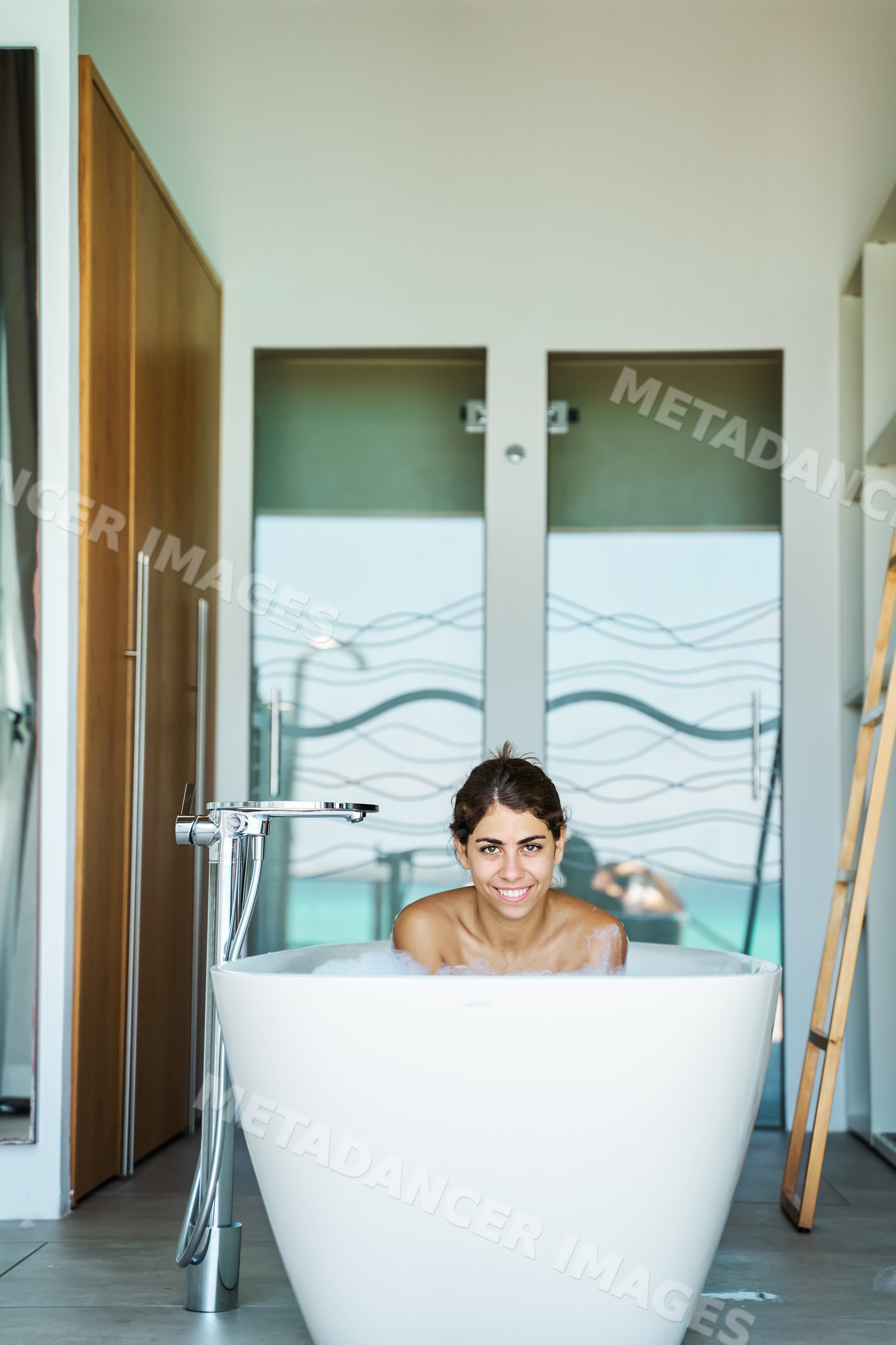 White Woman enjoying a bubble bath in a modern bathroom