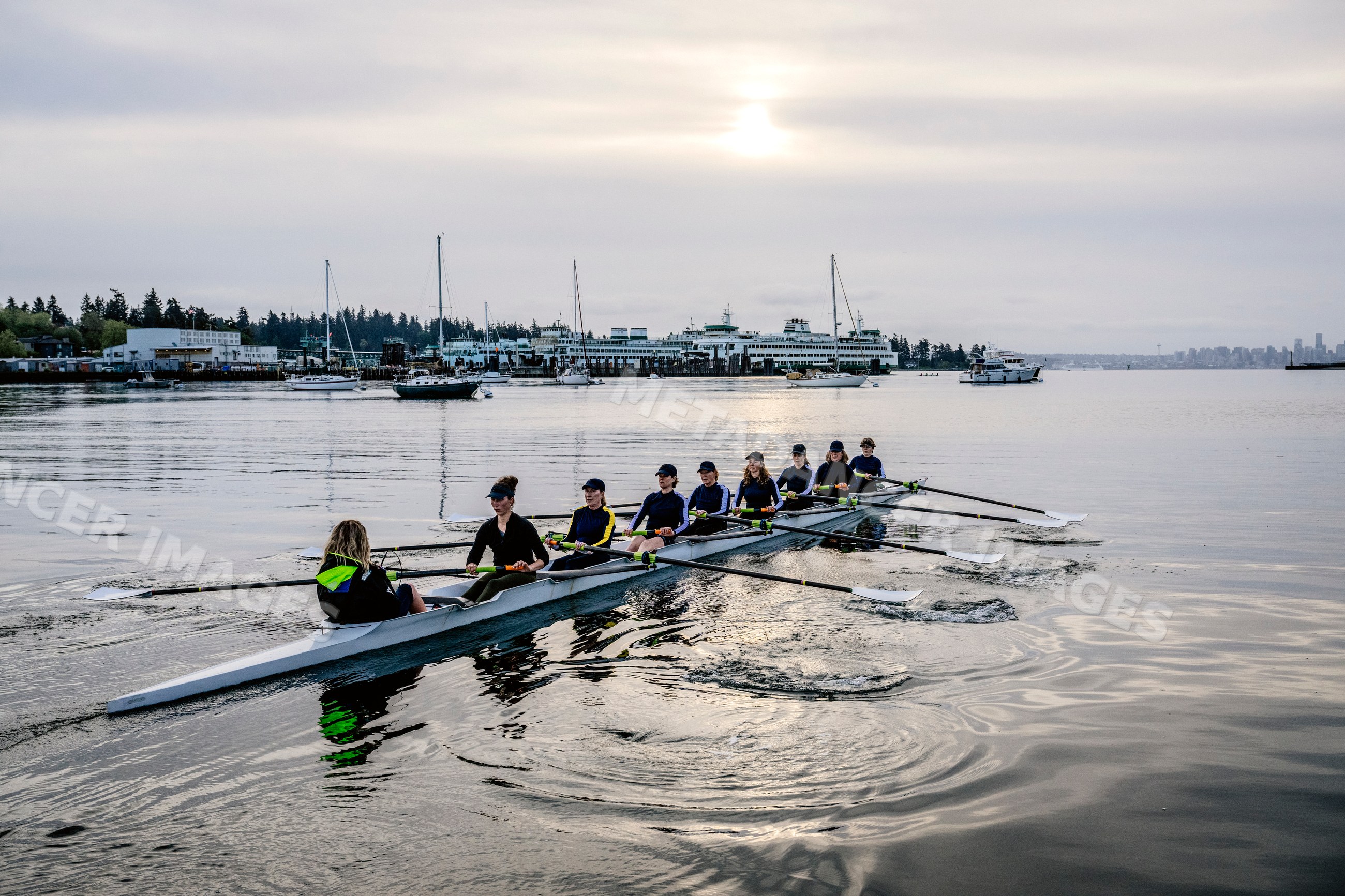 Eight-white person rowing team practicing on calm water in washington