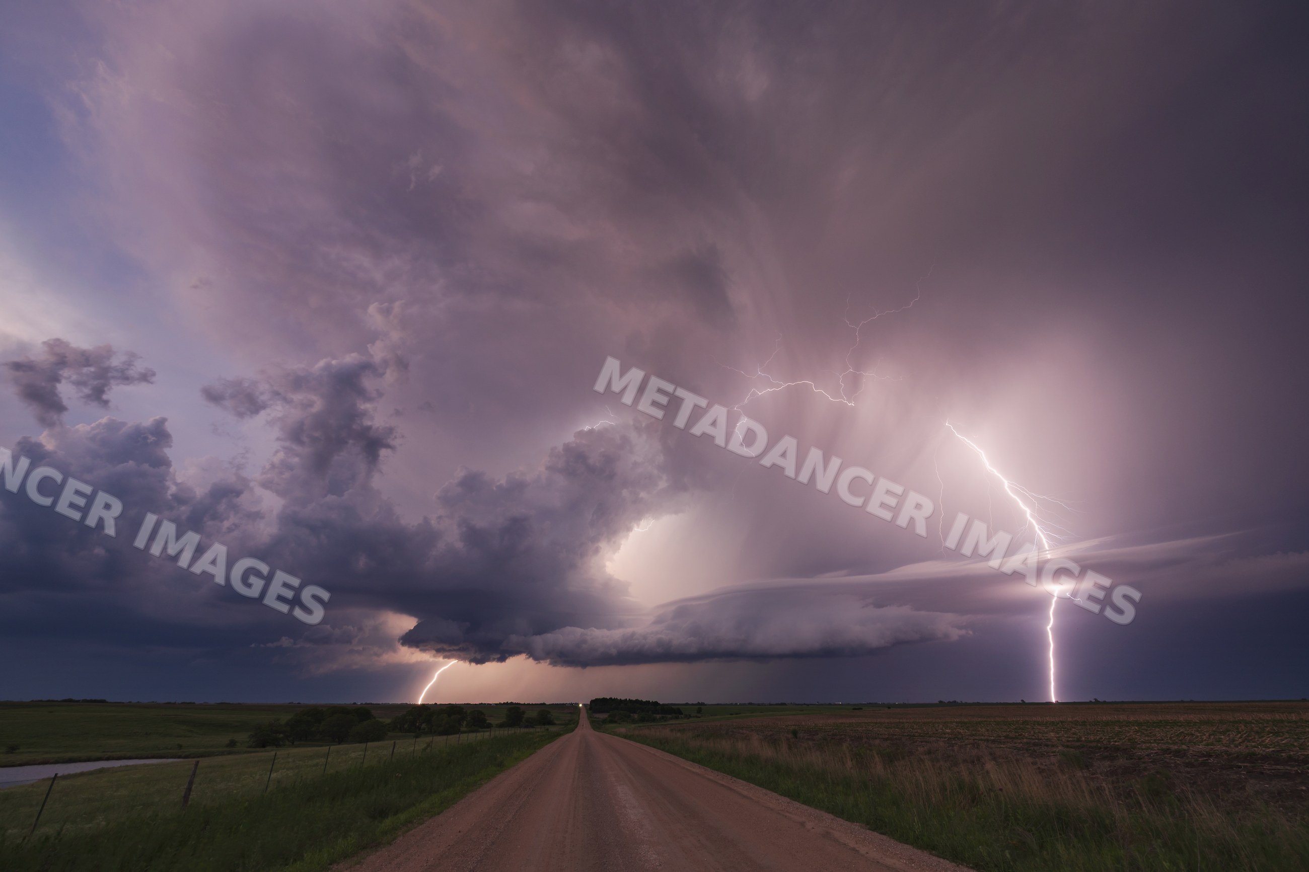 Supercell storm with Lightning over rural road at Dusk in nebraska