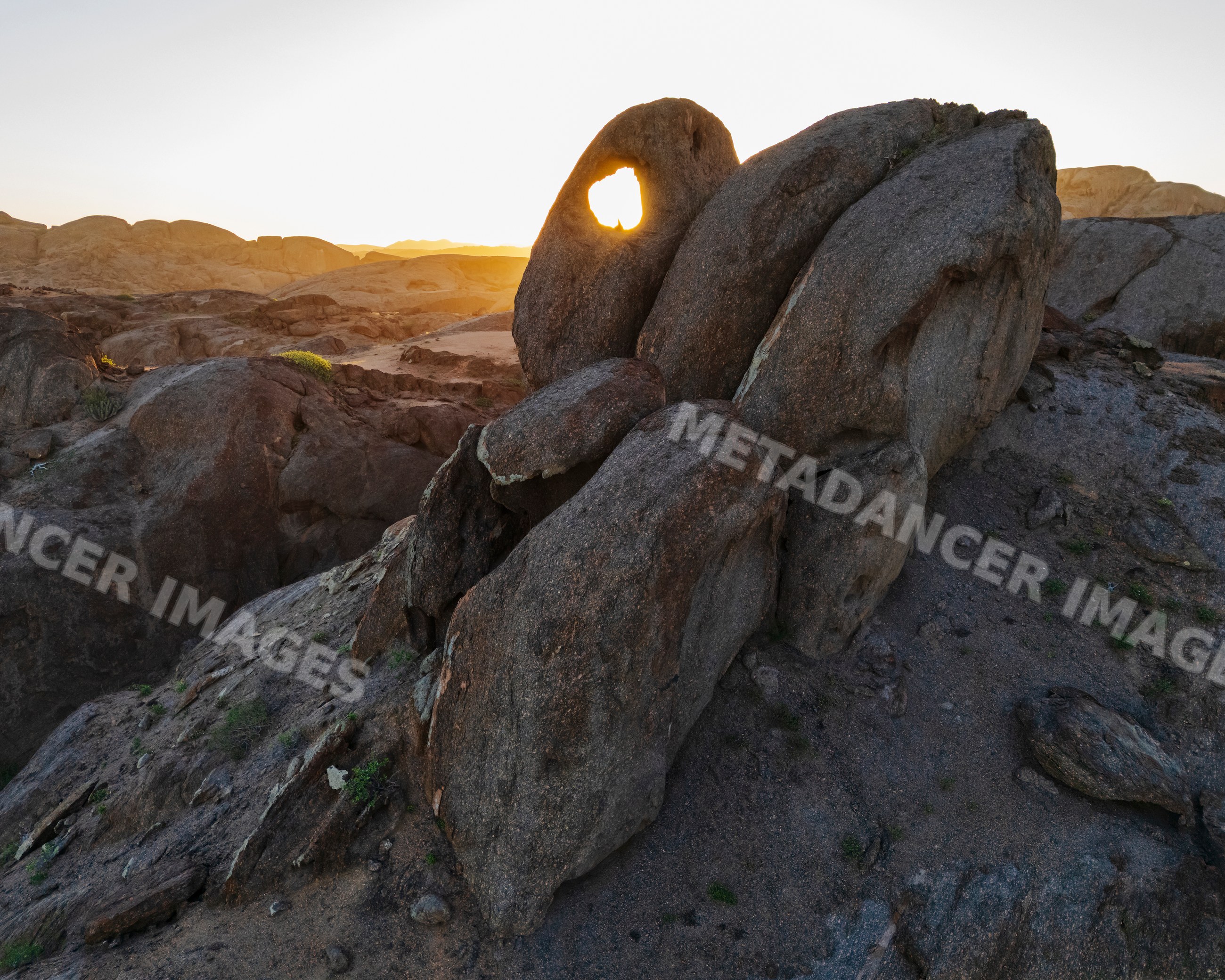 Hole in rock formation at Sunrise in stone valley, Namibia