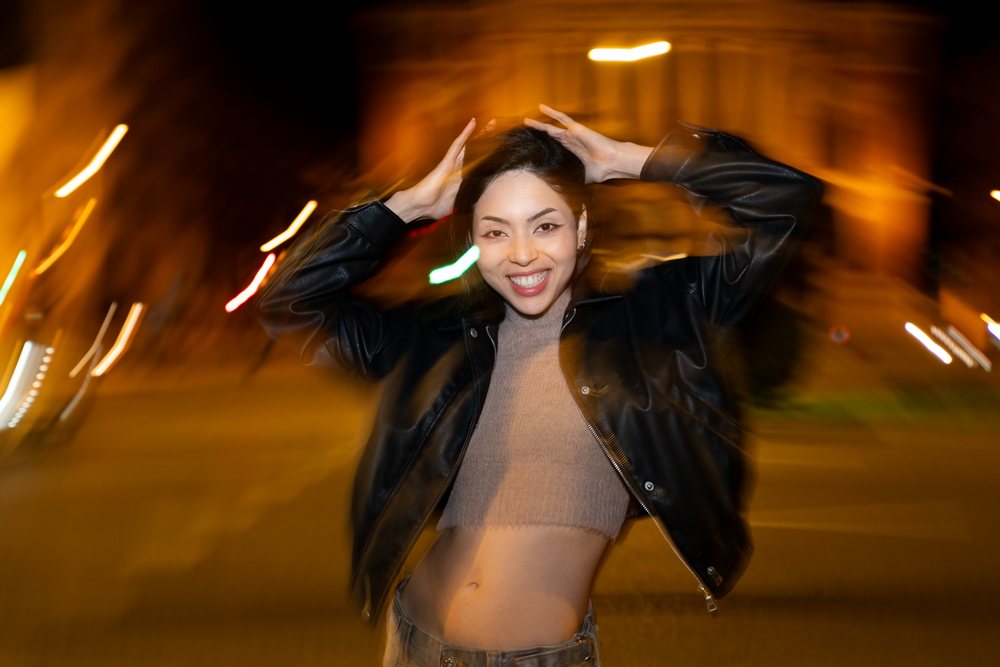 Hispanic woman smiling and posing at night on urban street in a street